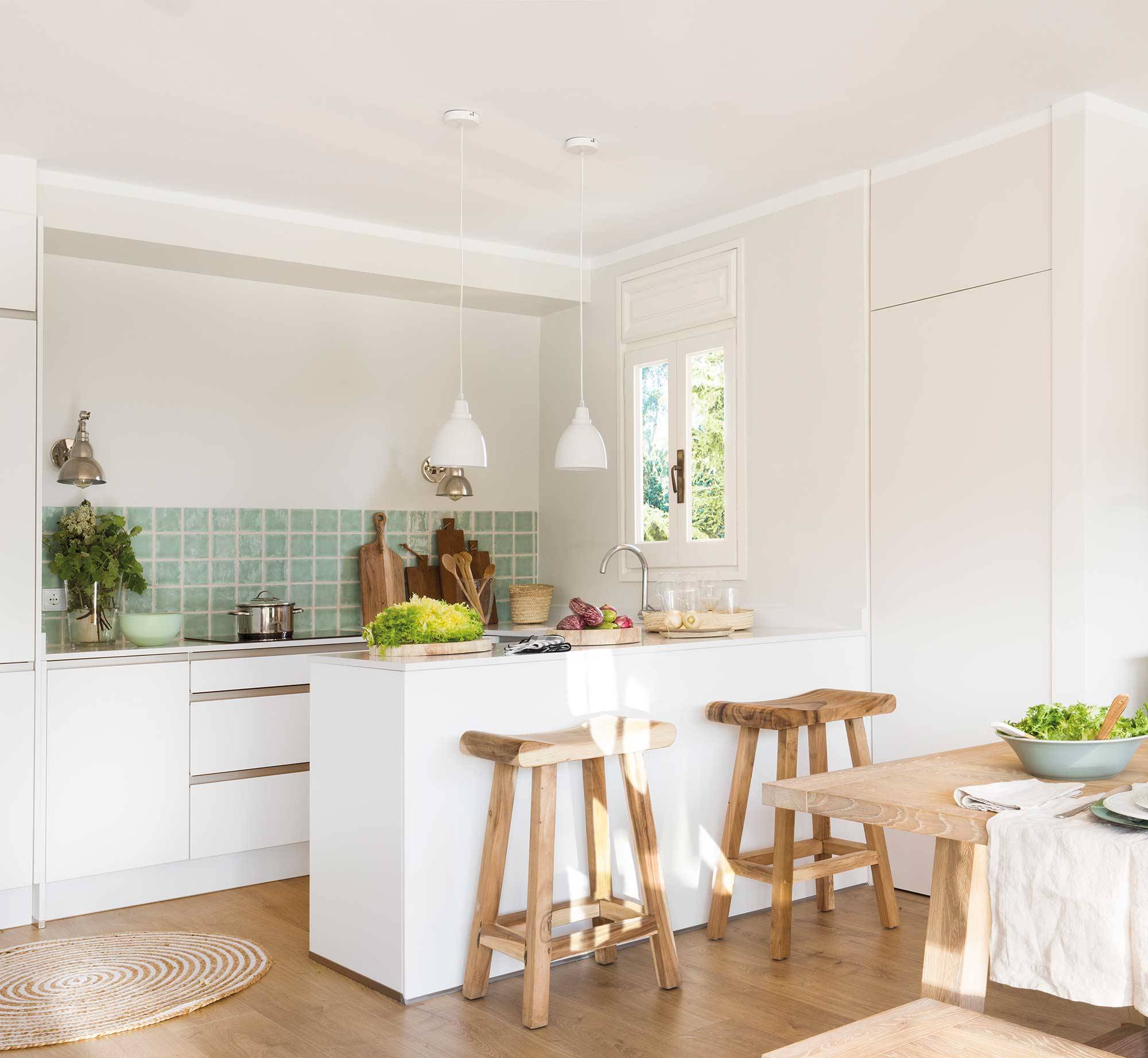 Cocina moderna blanca con antepecho de azulejos verdes. 