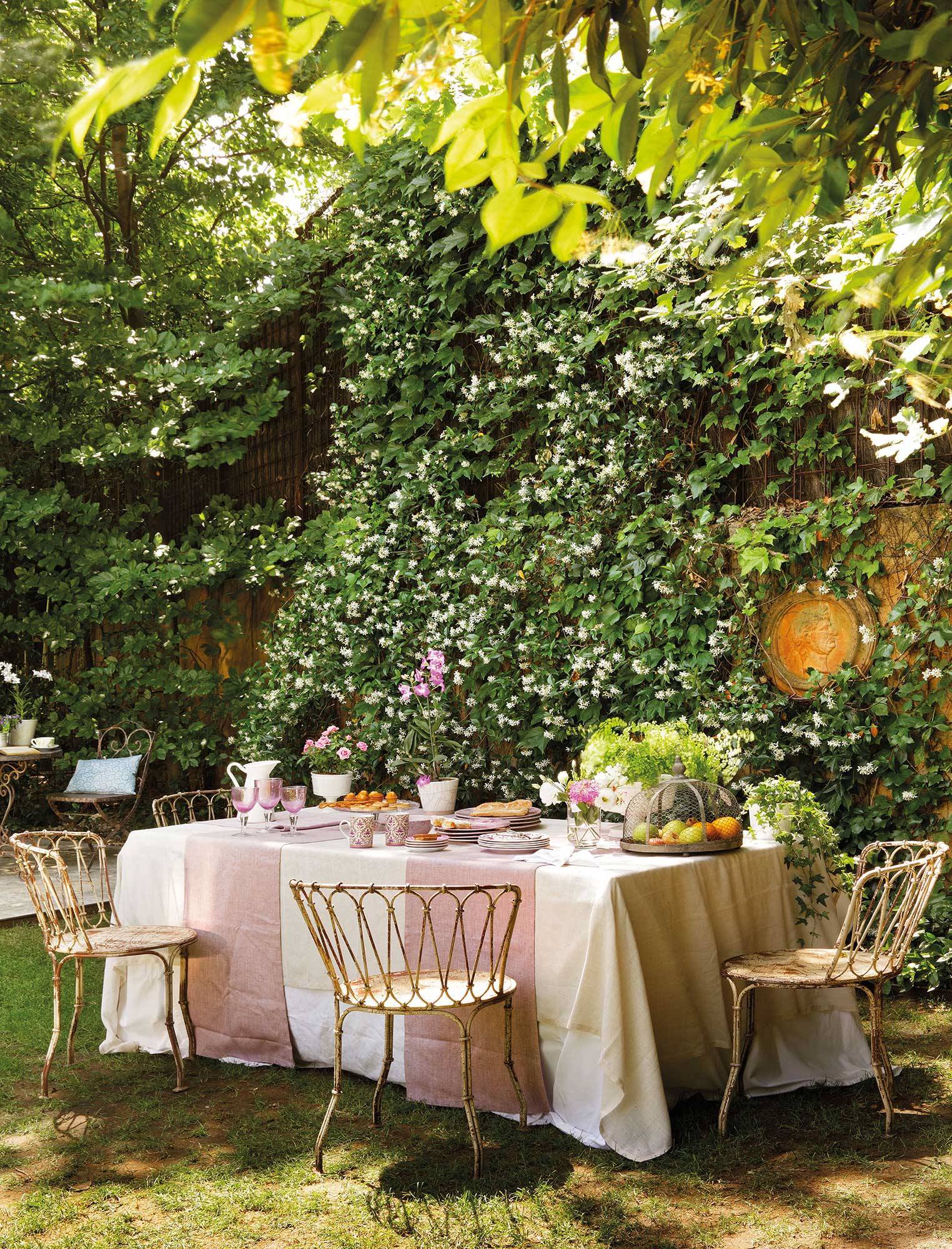 Comedor exterior con pared cubierta con plantas. 