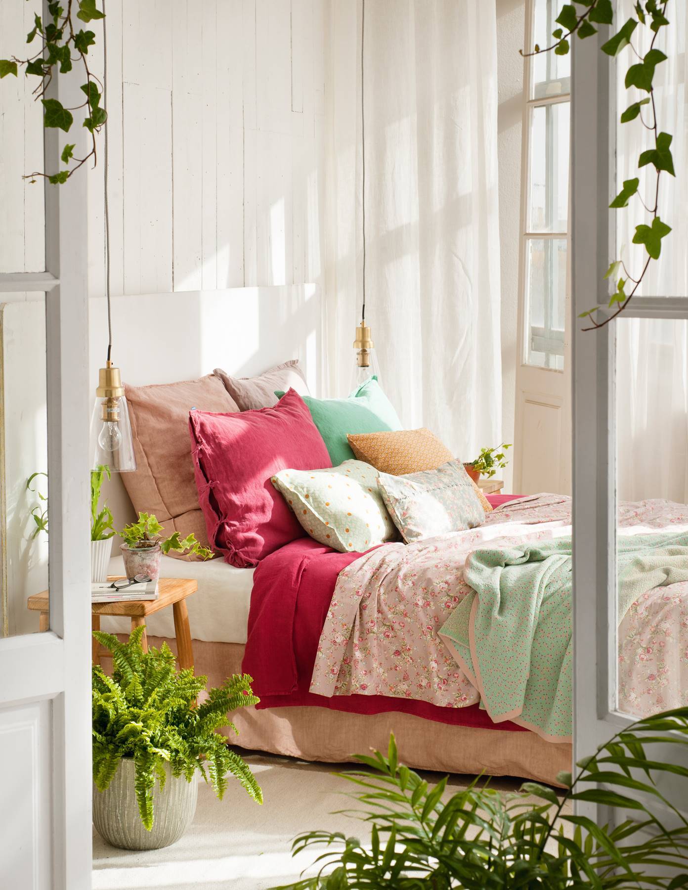 Dormitorio en tonos blancos y decorado con plantas. 