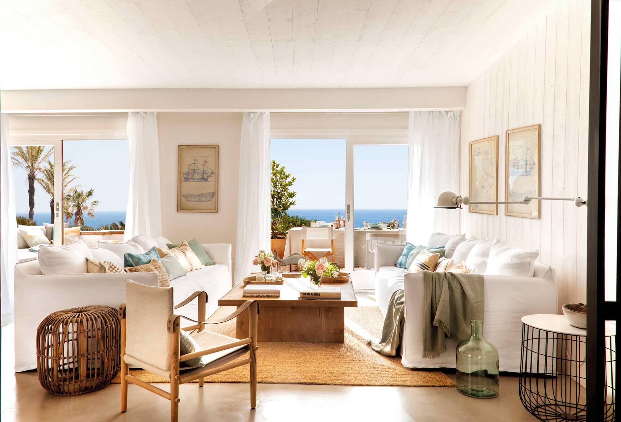 Salón de piso de verano con sofás blancos y alfombra de fibras.