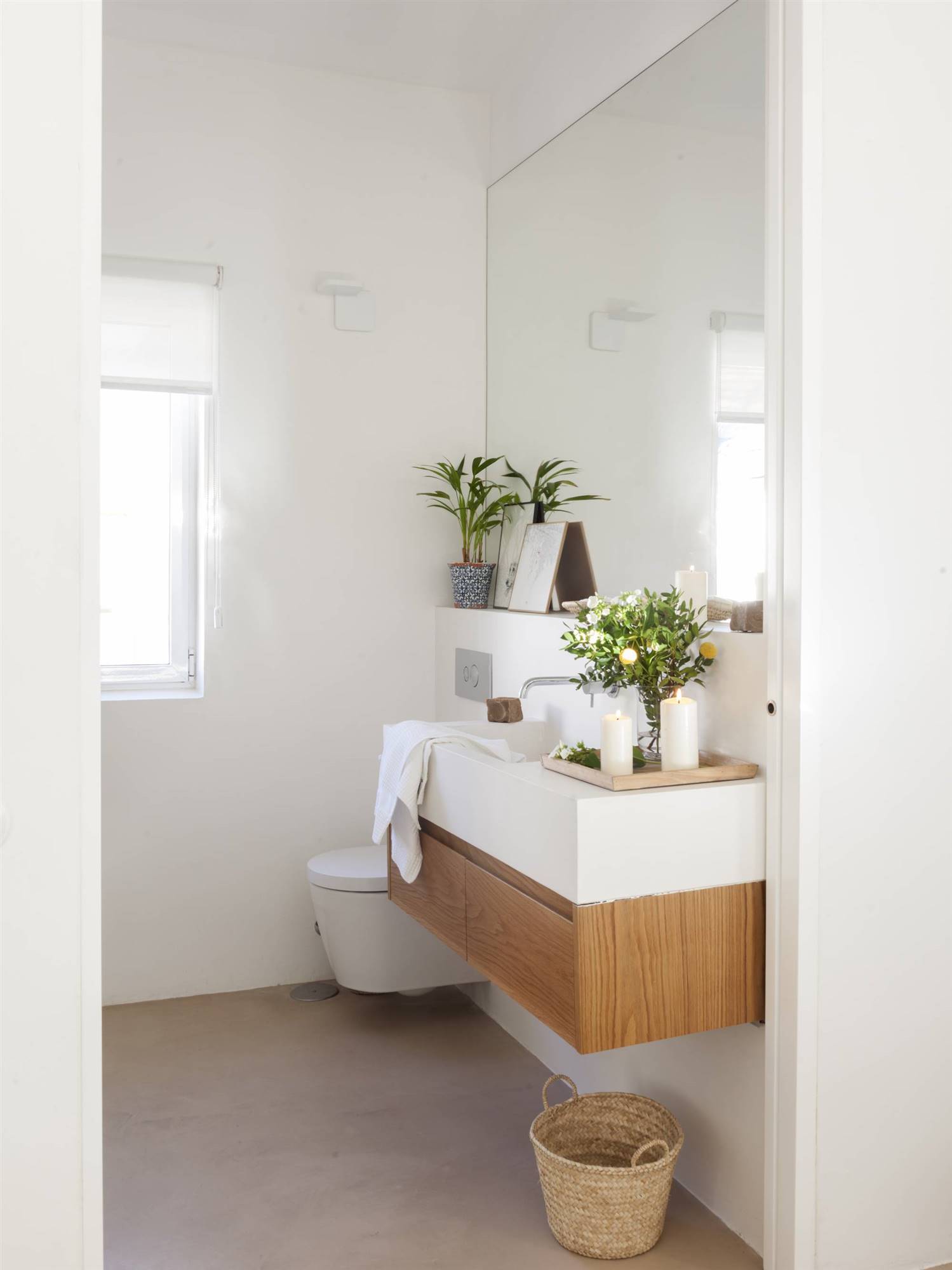 Baño pequeño en blanco con mueble de madera y gran espejo. 
