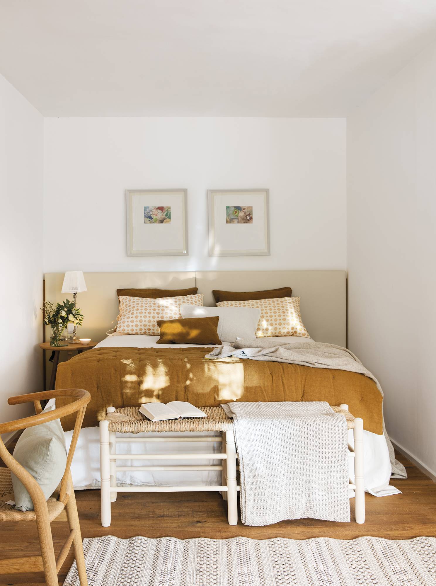 Dormitorio blanco con cama y cuadros en la pared