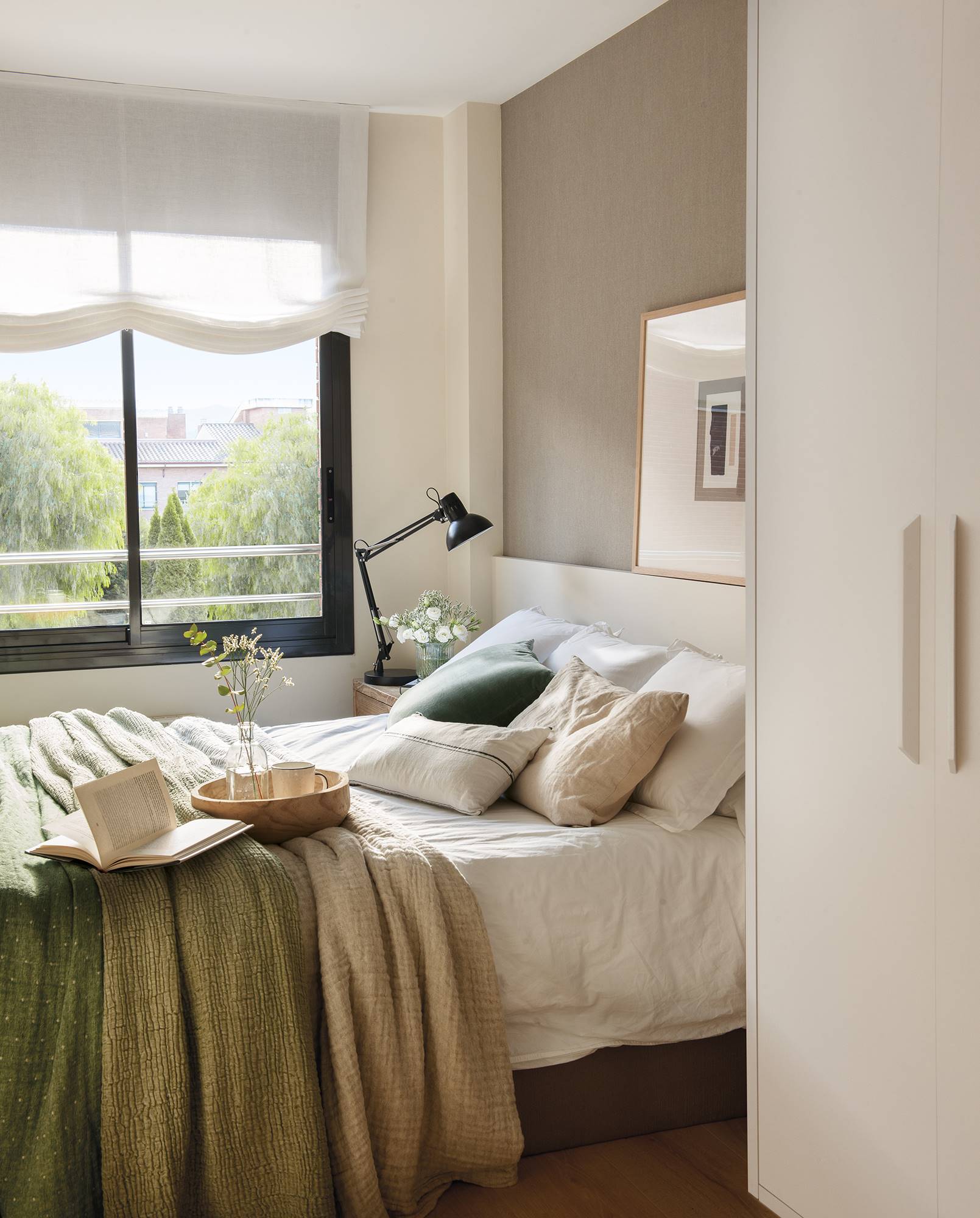 Dormitorio con cabecero con papel pintado y armario.