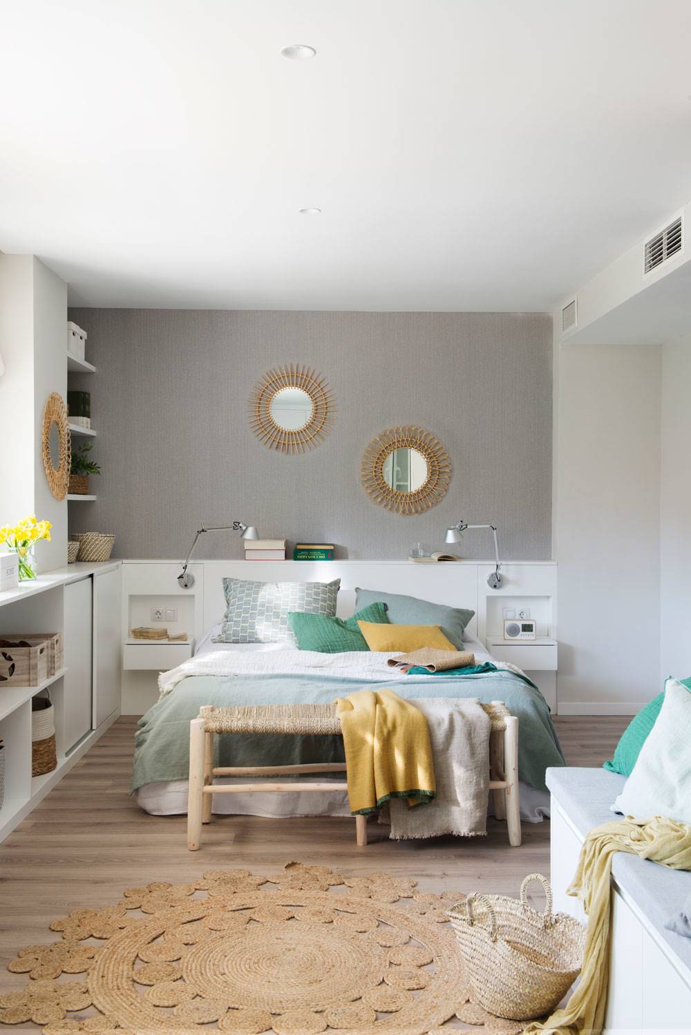Dormitorio con pared de color gris y cabecero blanco. 