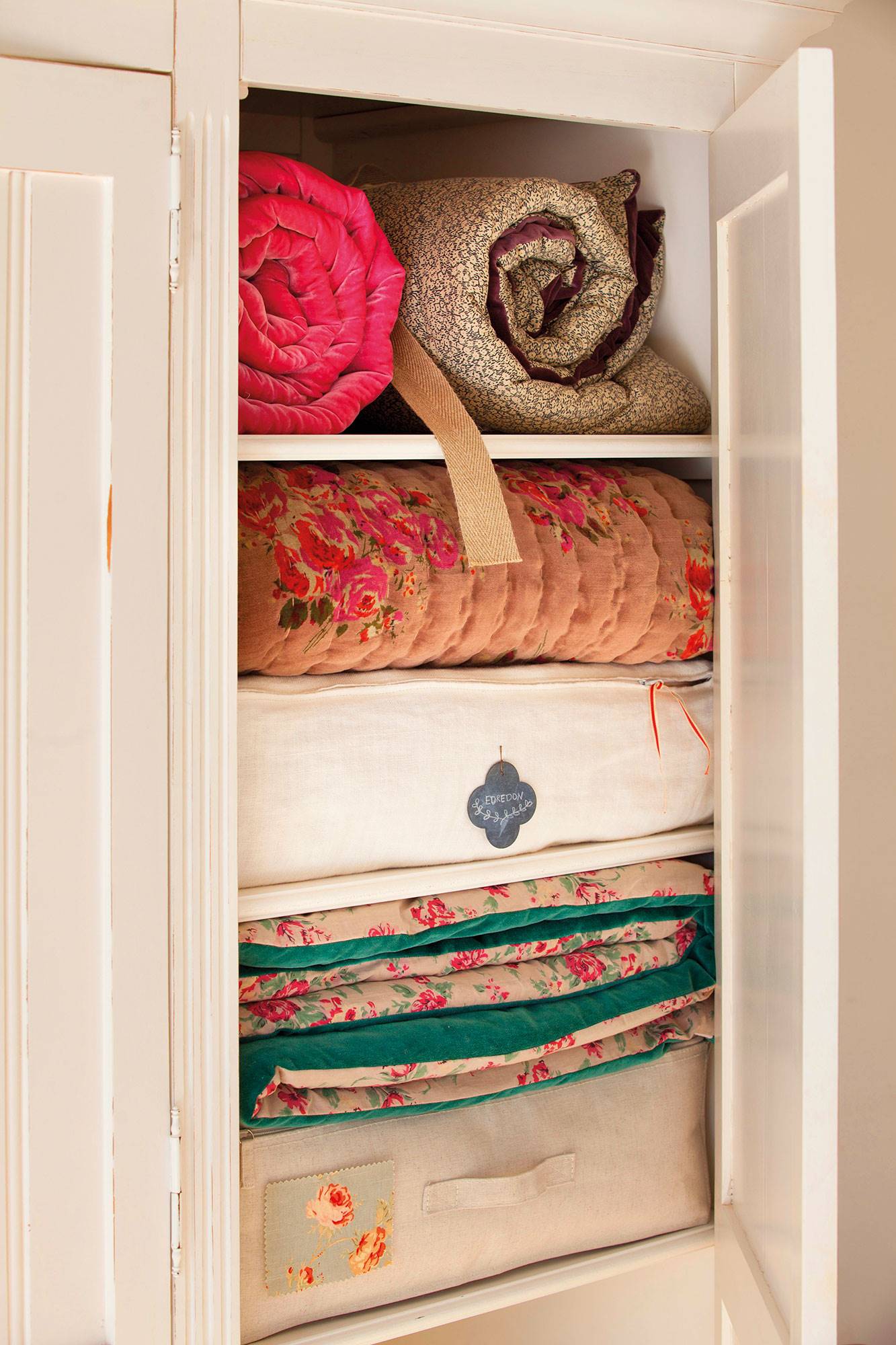 Detalle de armario con mantas y edredones guardados