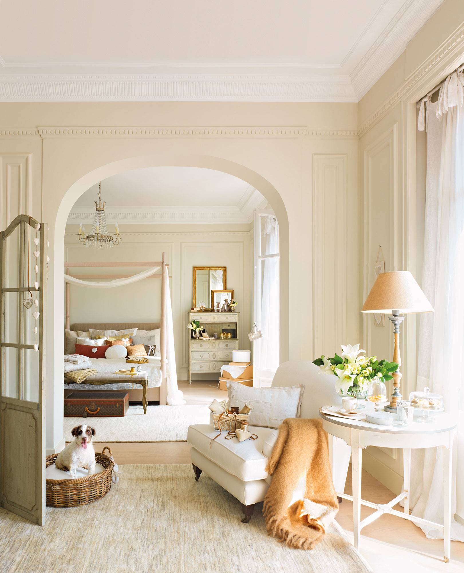 Dormitorio clásico en finca regia con cama con dosel al fondo y rincón de lectura en primer plano