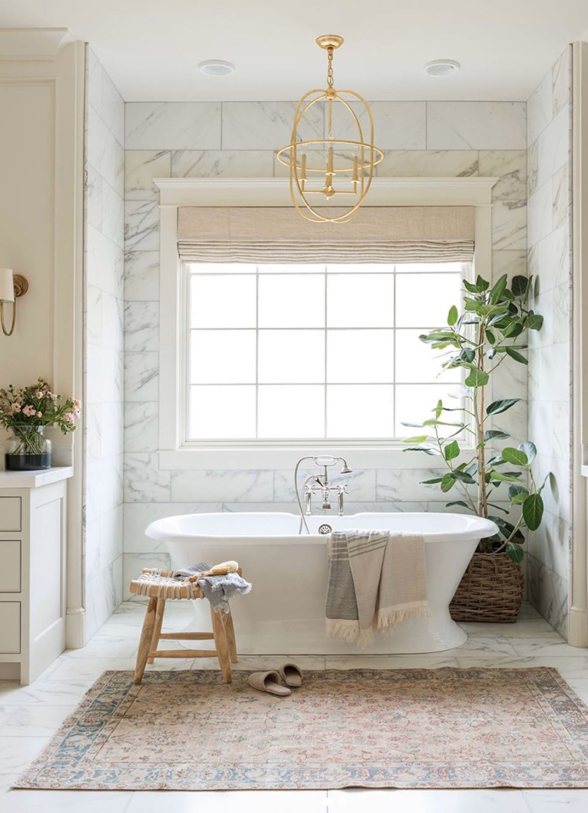 Baño con bañera y paredes de mármol