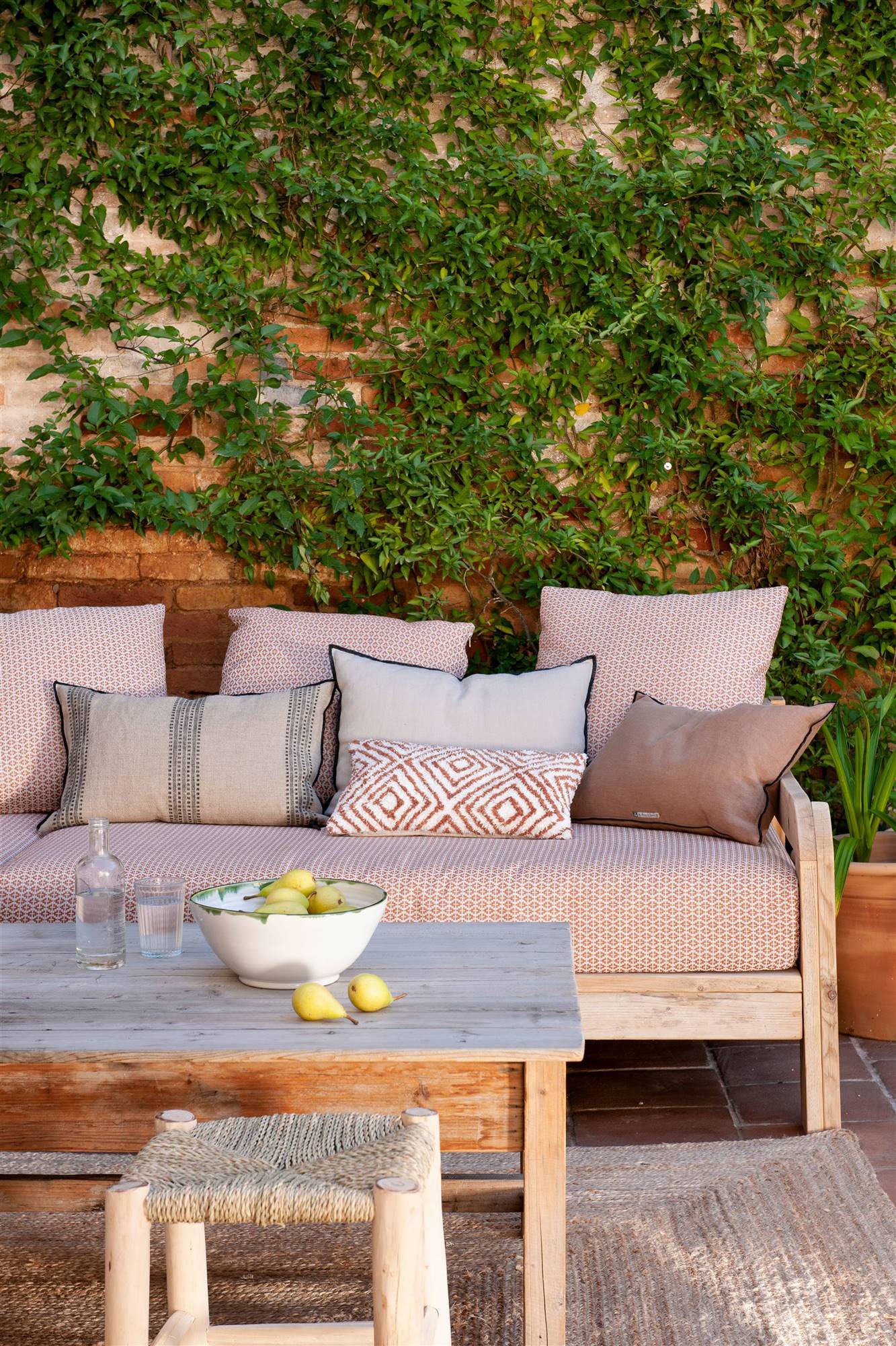 terraza con sofa mesa y taburete de madera y alfombra de fibras_00510308_O