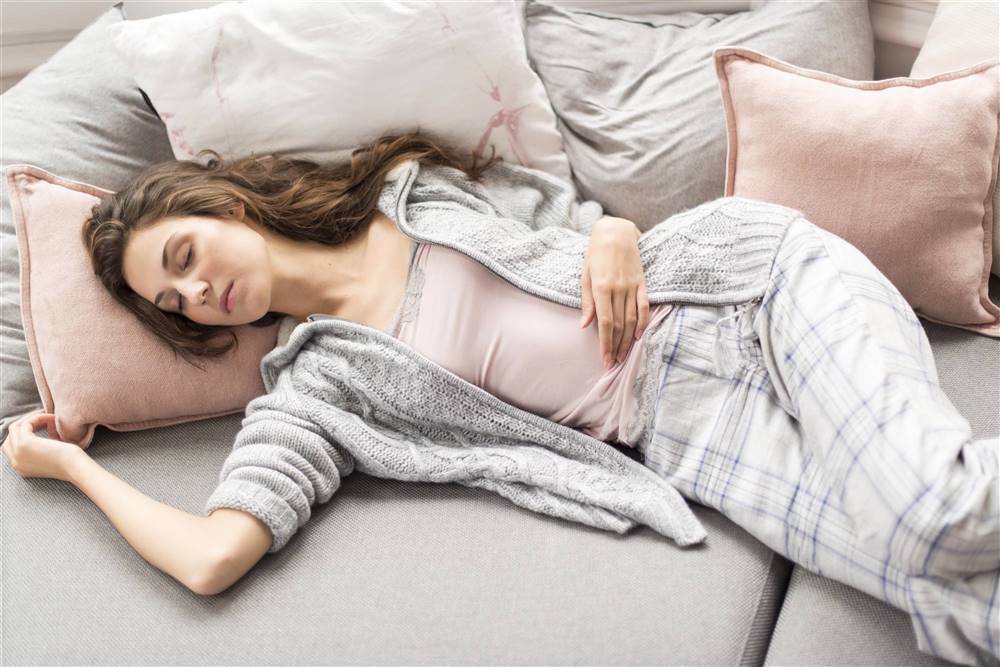 Mujer durmiendo en el sofá con pijama