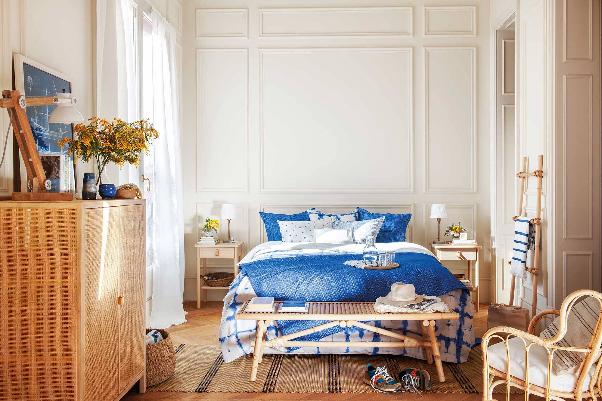 Dormitorio de primavera de estilo clásico con molduras y ropa de cama azul y blanca.