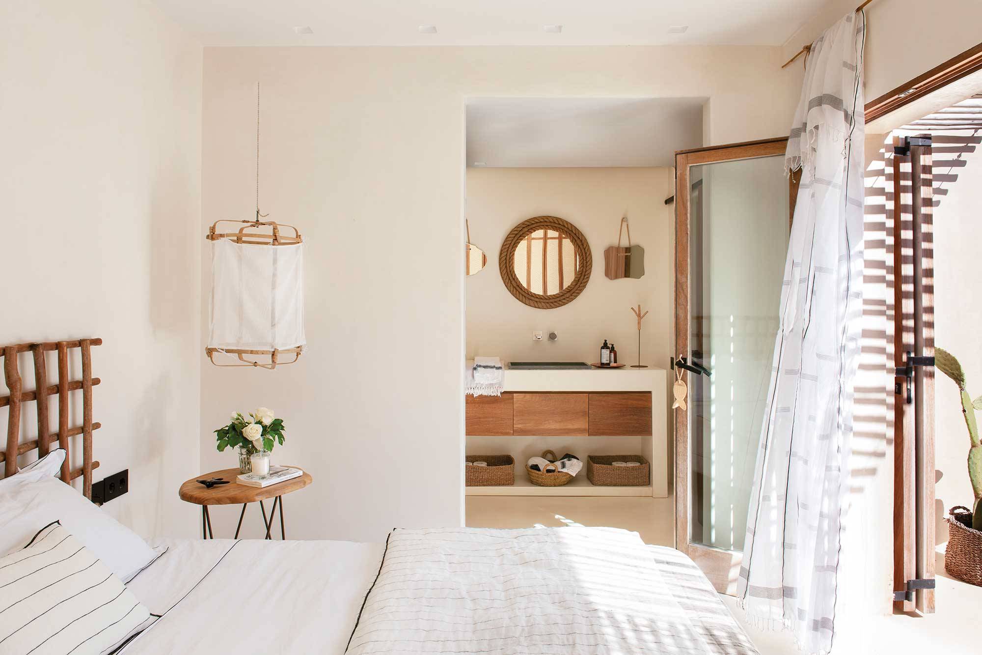 Dormitorio de primavera en blanco y madera con baño integrado.