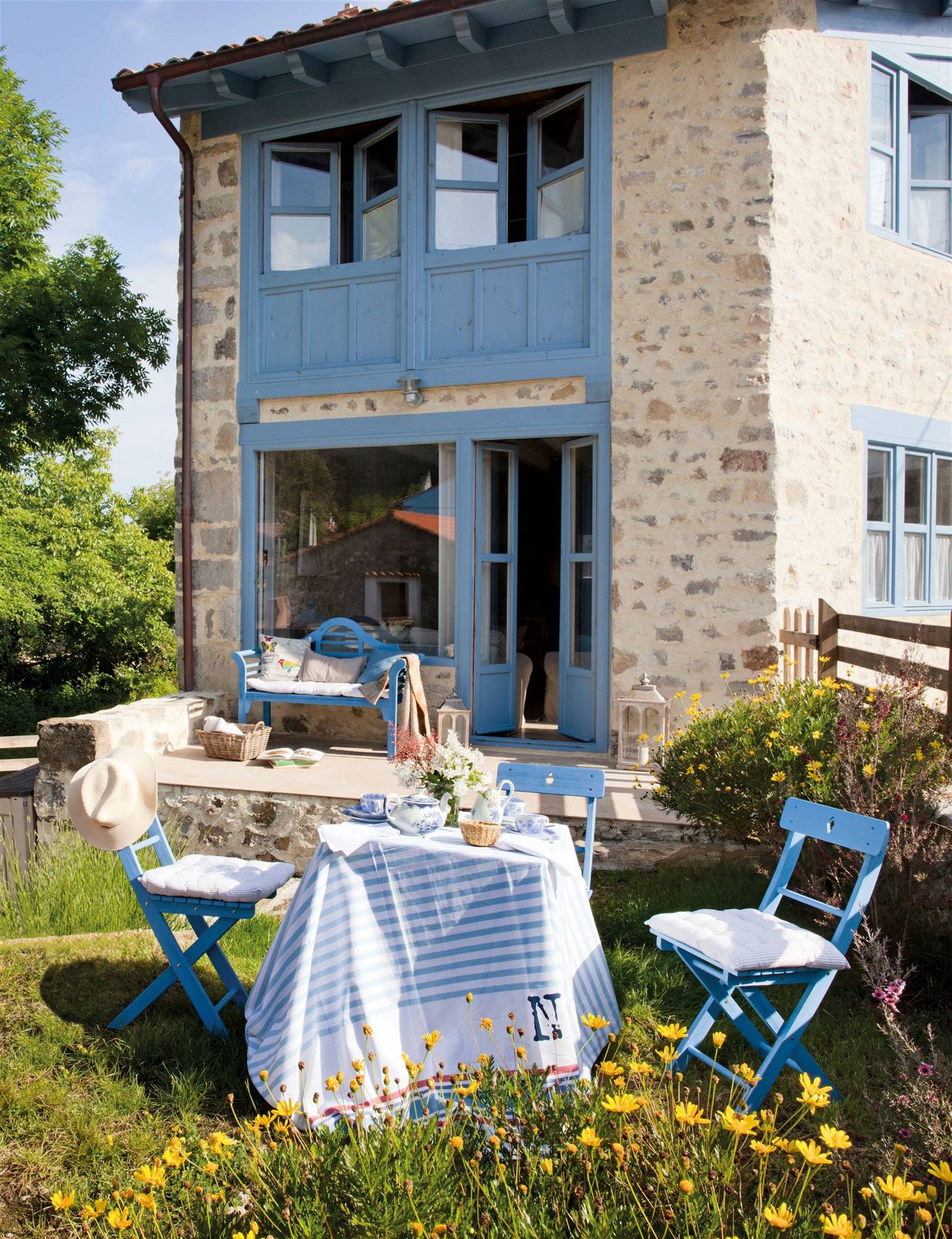 mesa y sillas de exterior azules en el jardin 00386225
