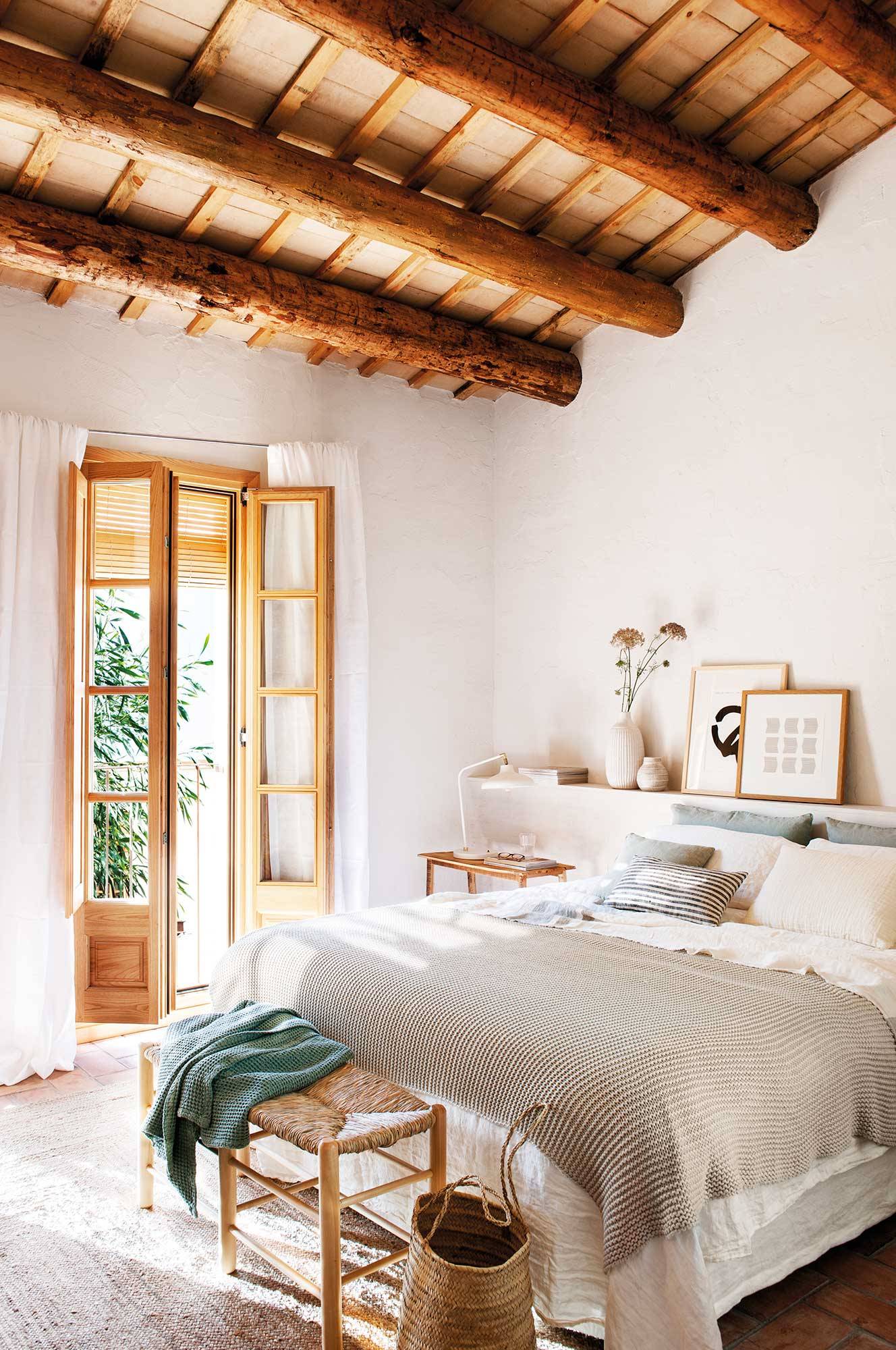 Dormitorio con ventana y contraventana de madera.