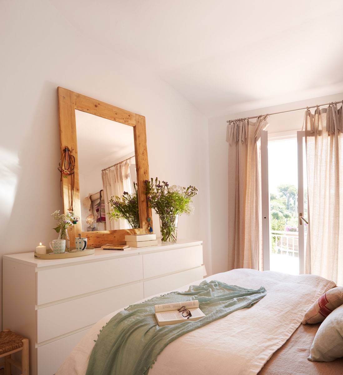 Dormitorio con cómoda a los pies de la cama y espejo de madera
