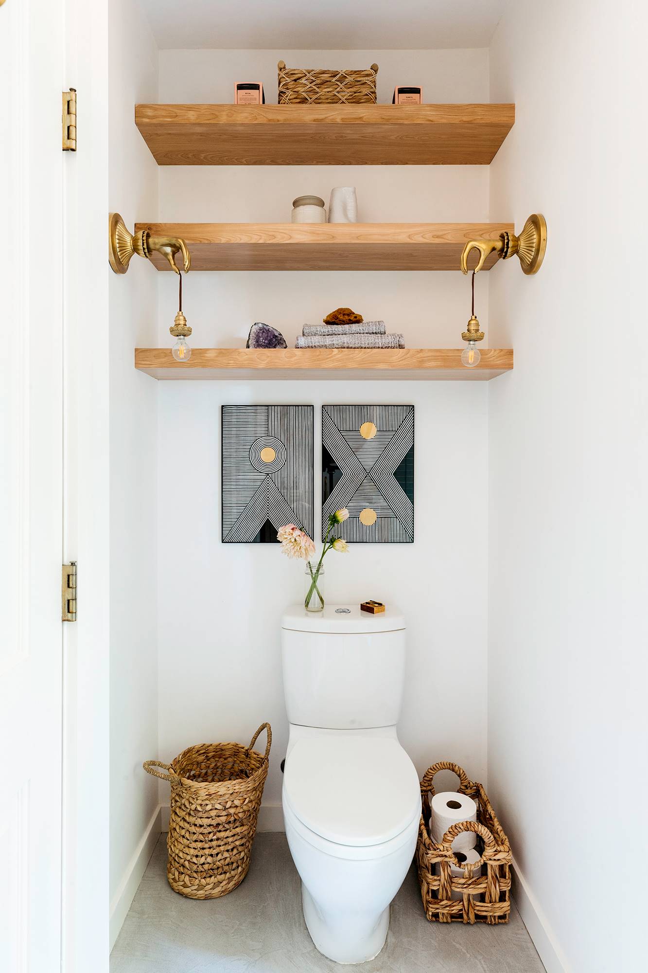 Baño de estilo rústico con inodoro y baldas de madera en la pared