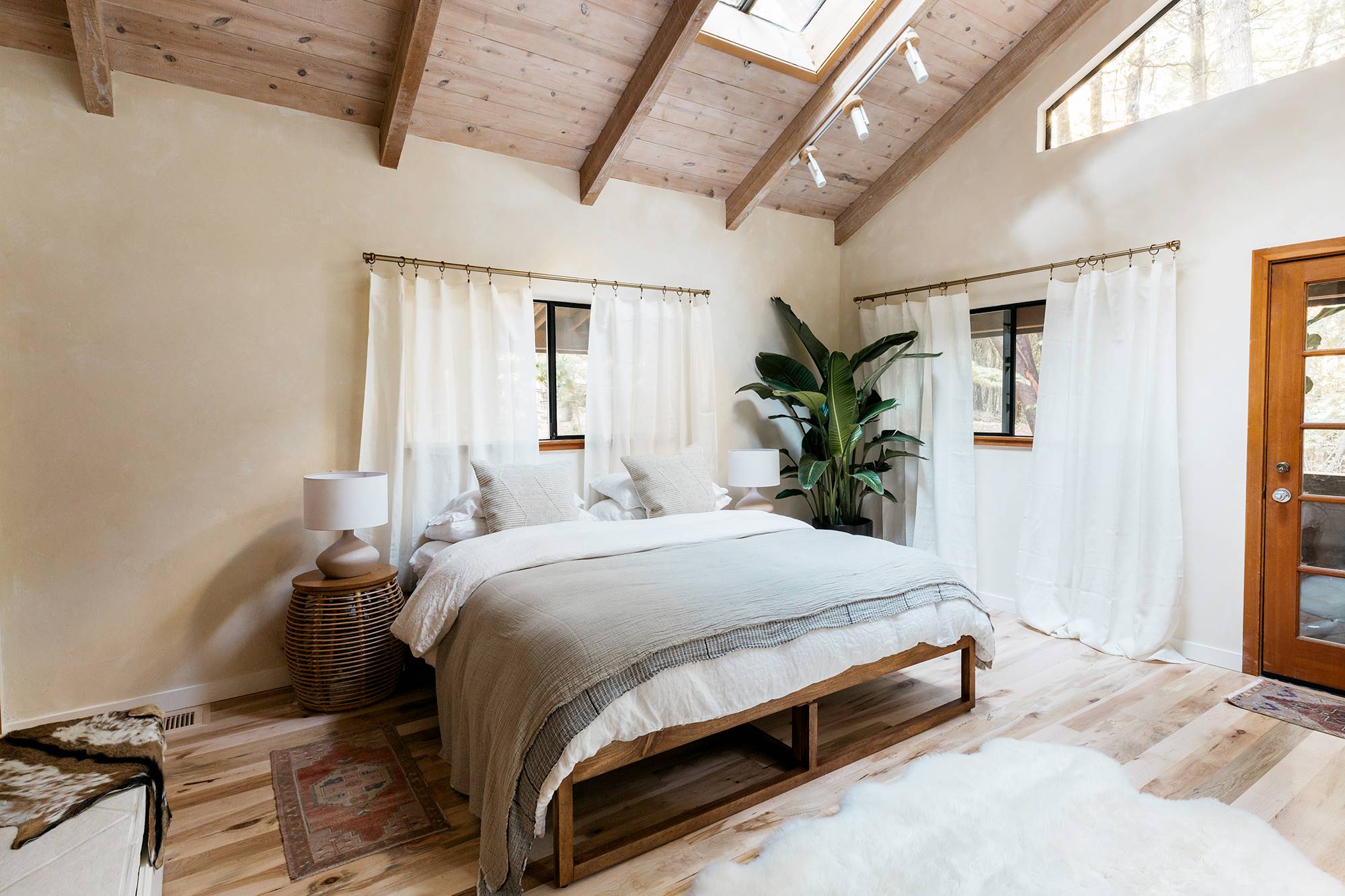 Dormitorio decorado en tonos neutros con mobiliario de madera y plantas