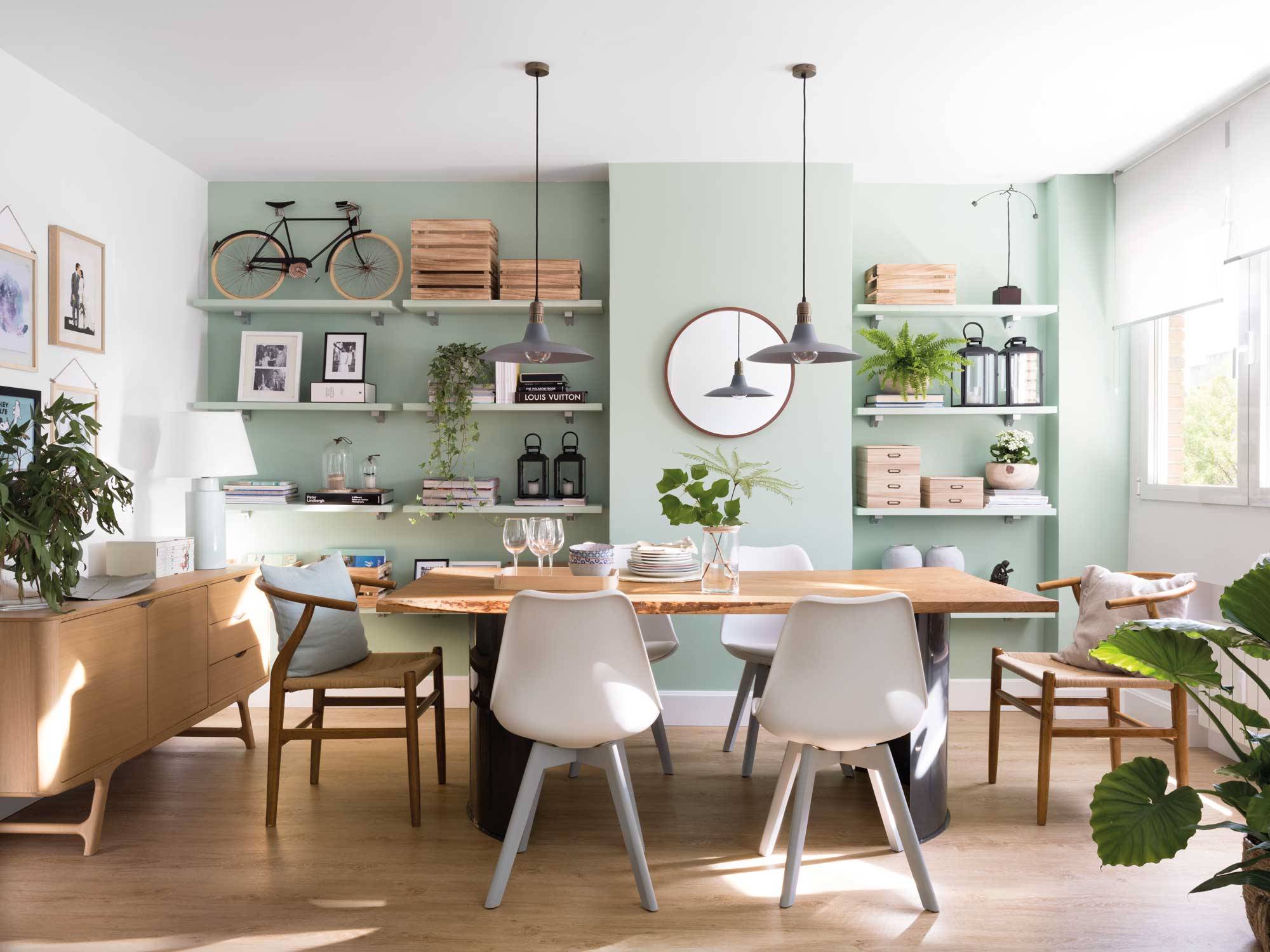Comedor en madera con pared en color verde y estantería