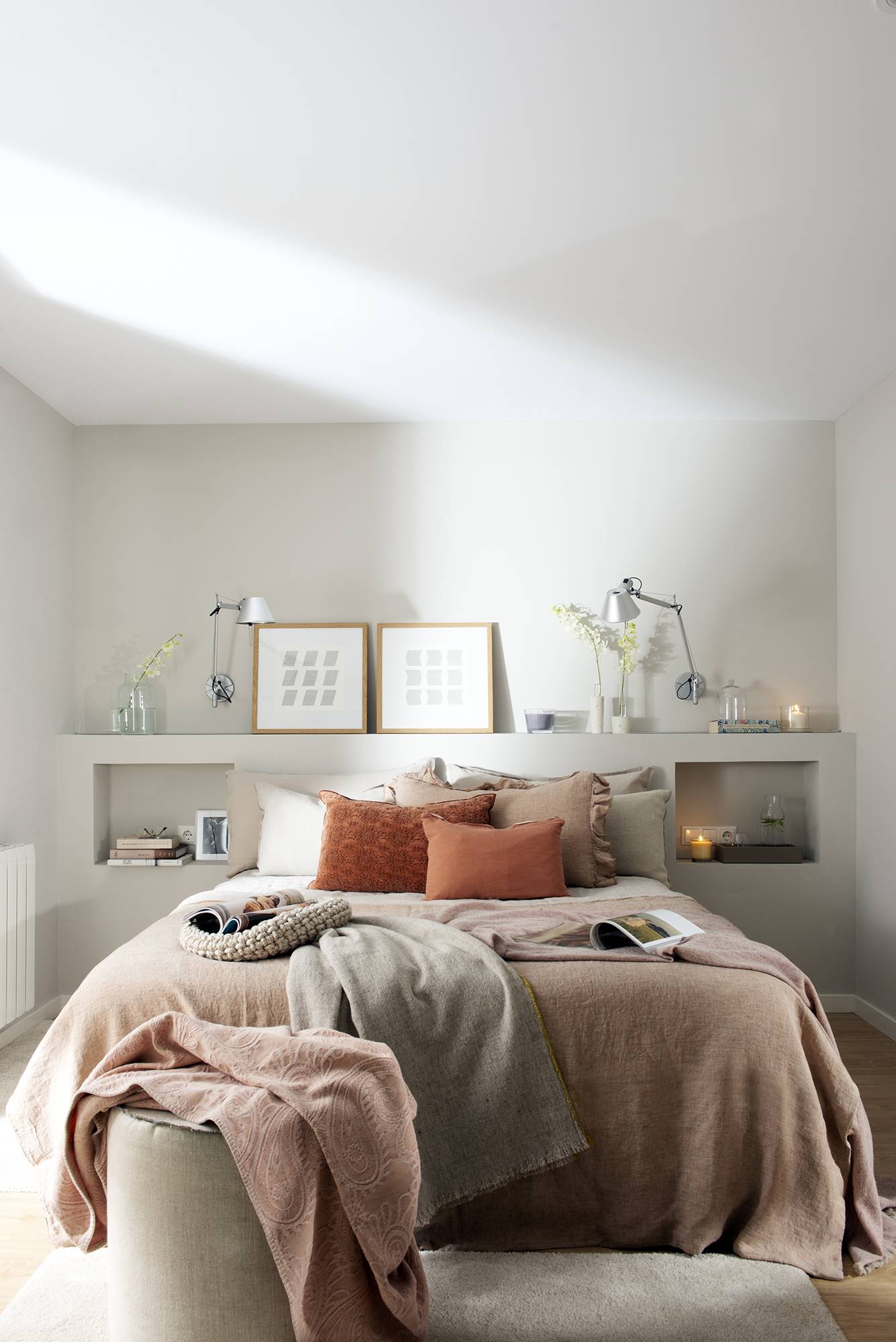Dormitorio moderno con pared gris y cabecero de obra.