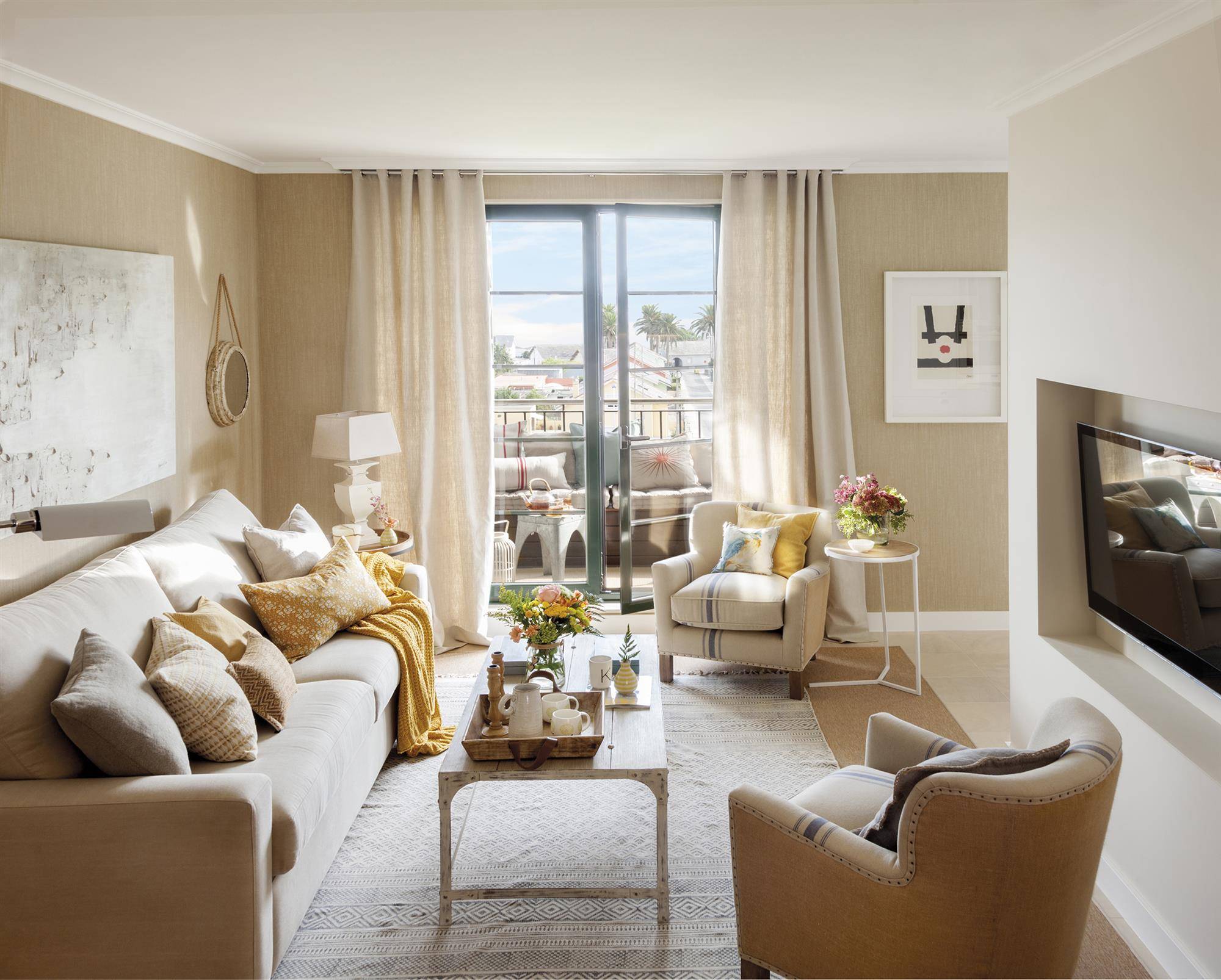 Salón con acceso a terraza decorado en tonos beige con detalles mostaza