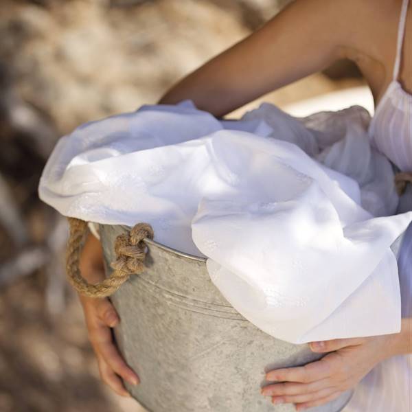 mujer sosteniendo un barreno con ropa blanca 