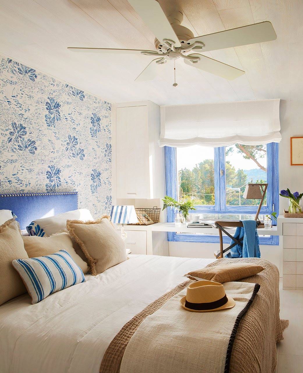 Dormitorio con cabecero en papel pintado azul y blanco