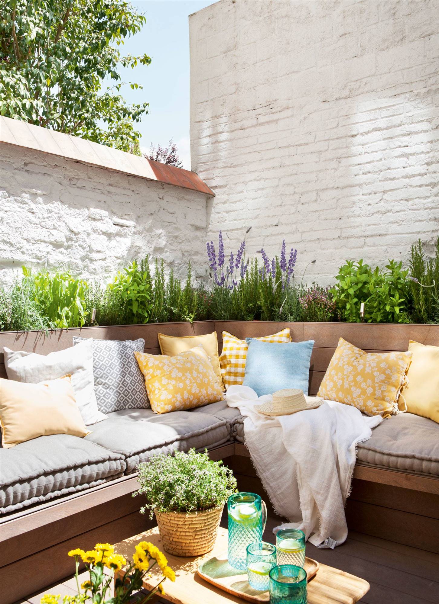 Terraza con banco en "L", paredes blancas y jardineras con plantas aromáticas_00433266