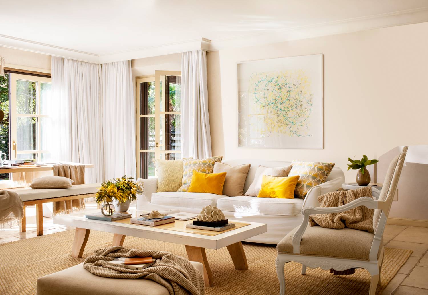 Salón beige con sofá blanco, mesa de centro, cuadro y cojines amarillos_428054
