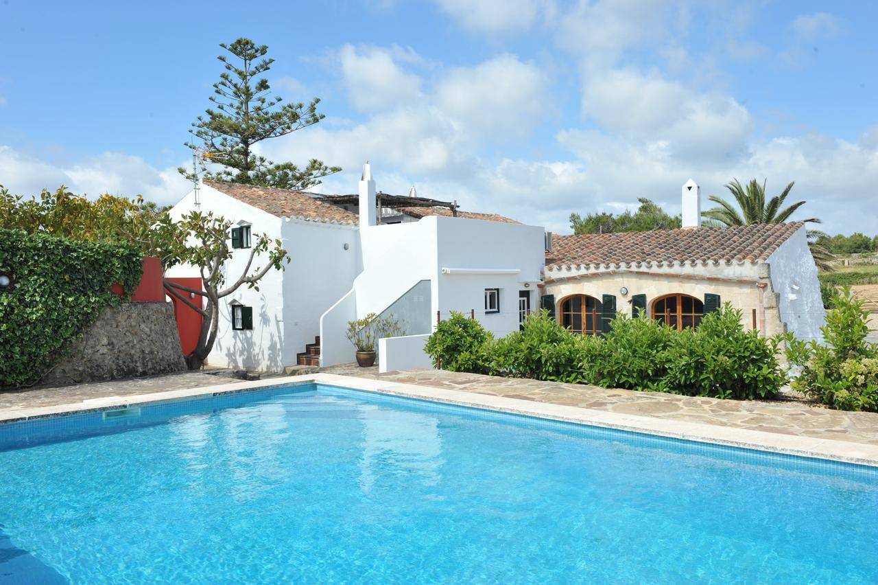Casa rústica con fachada blanca y piscina