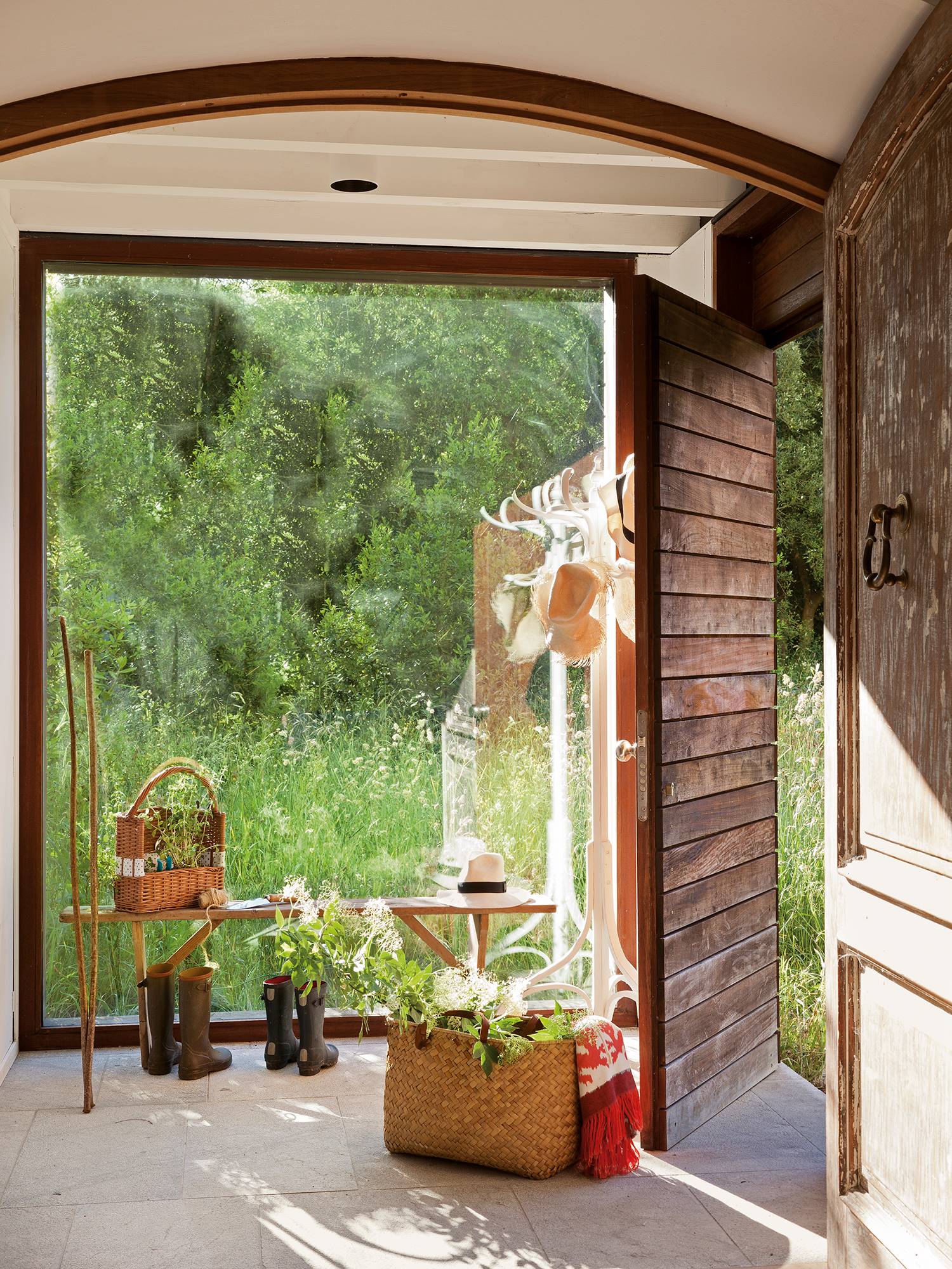 Recibidor rústico con banco de madera y ventanal con vistas al campo