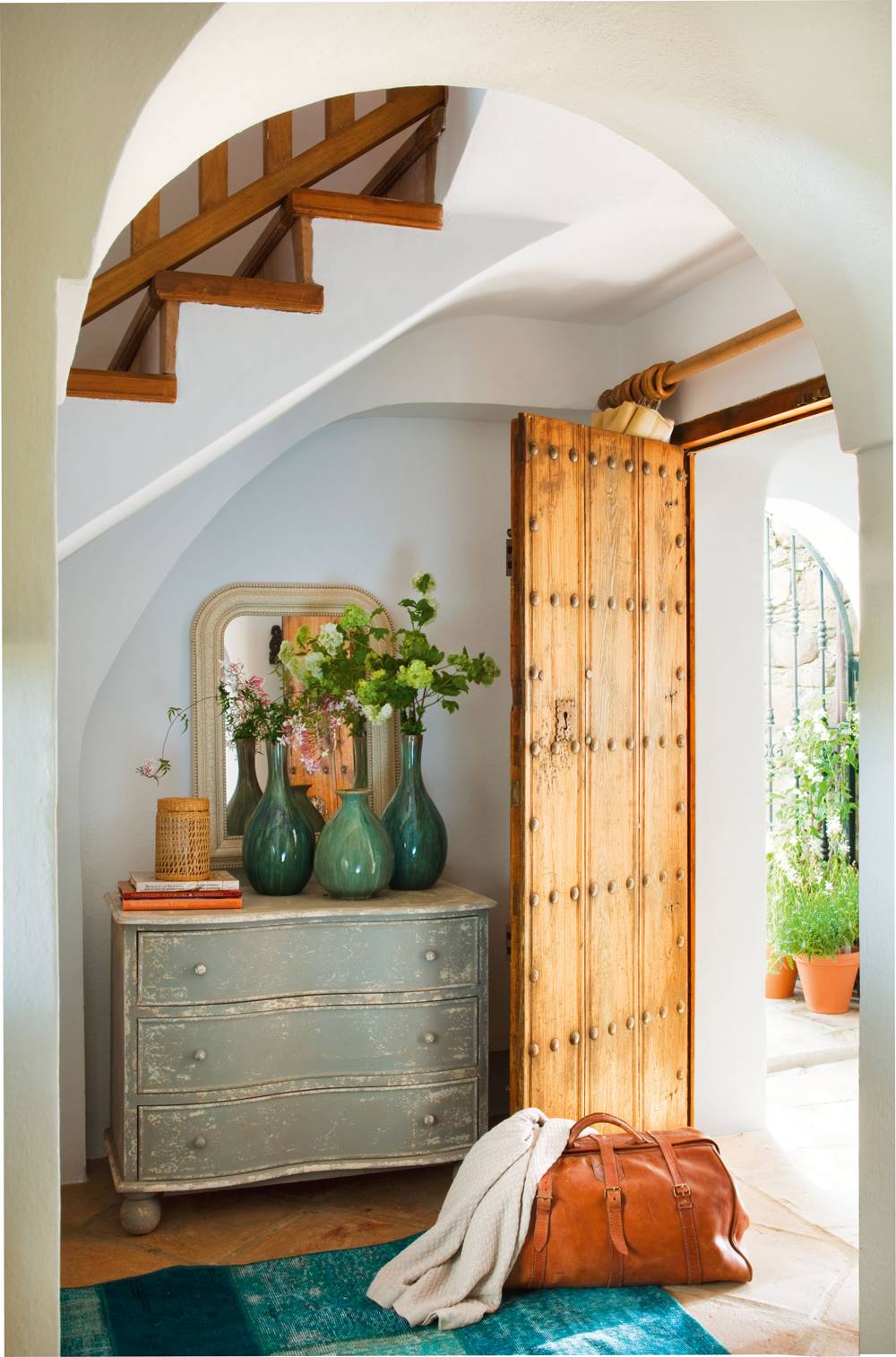 Recibidor rústico con puerta de madera, cómoda pintada y alfombra azul (00345177)