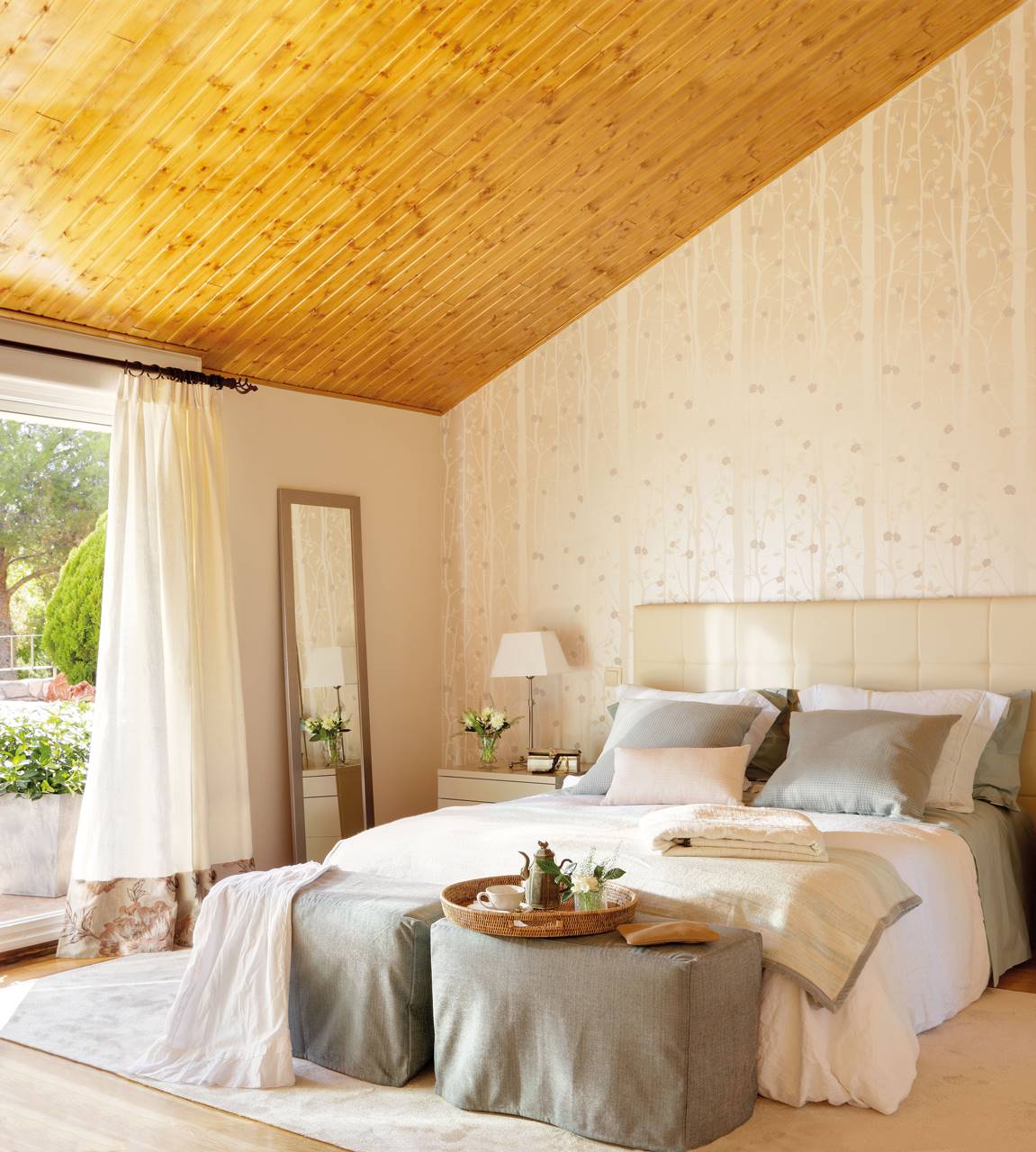 Dormitorio de verano con pared empapelada y ropa de cama gris claro y blanco. 