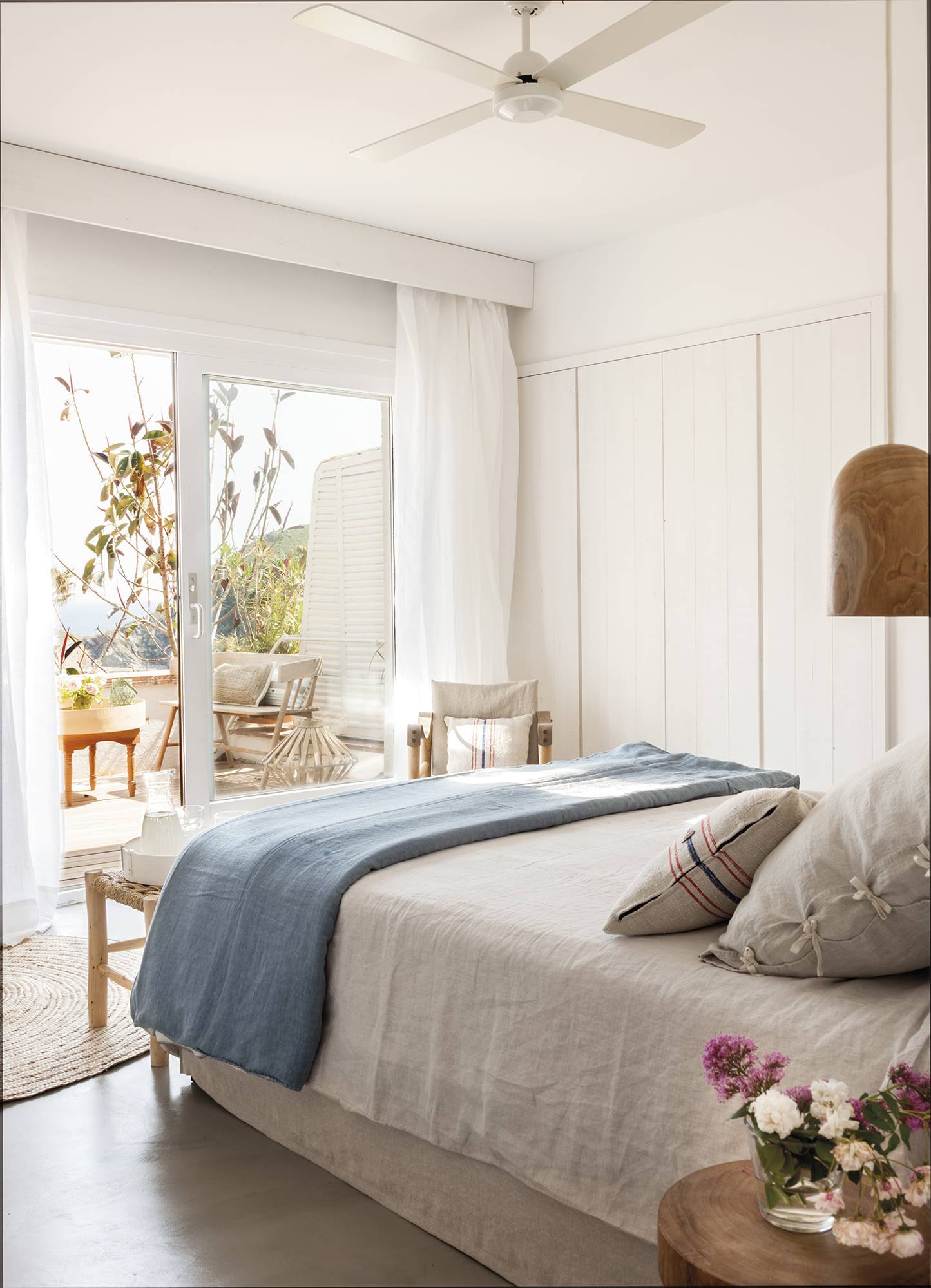 Dormitorio de verano con todo en blanco y plaid en azul. 