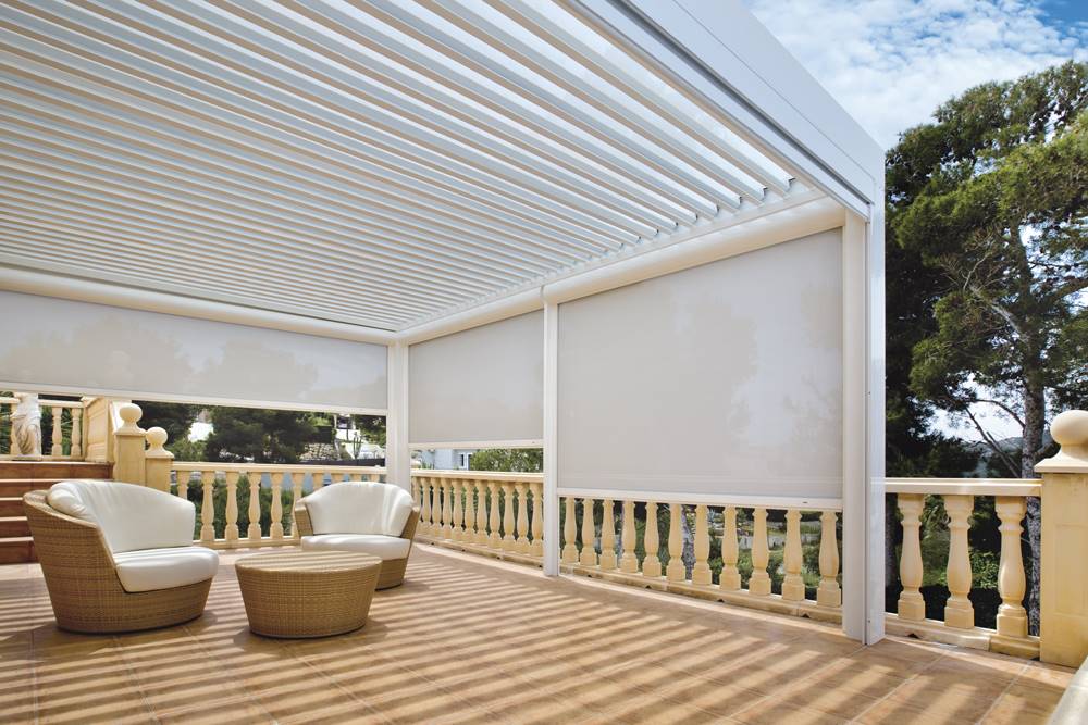 Terraza con pérgola Saxun en blanco y muebles de exterior en fibra natural