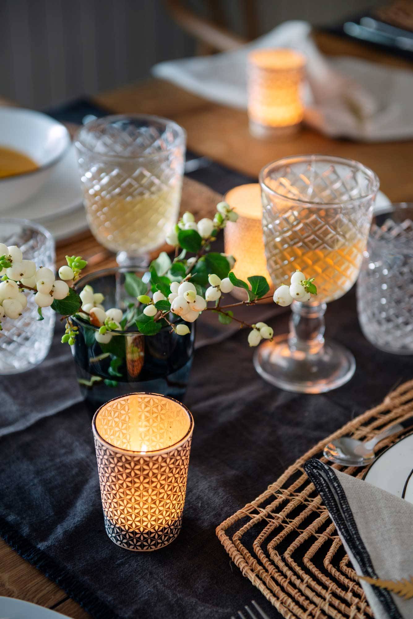 Detalle de una mesa decorada con velas y copas. 