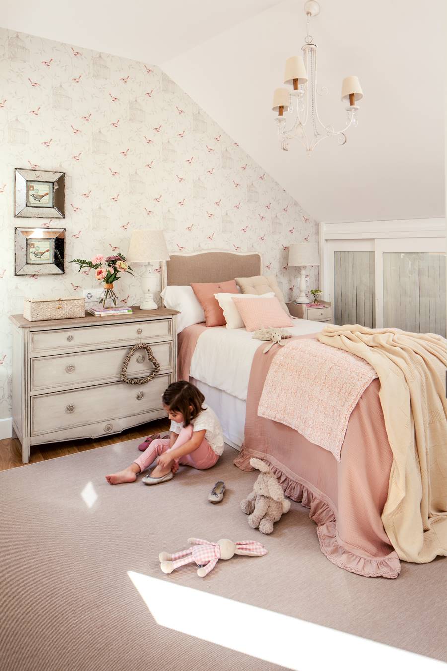 Dormitorio infantil con niña en el suelo y cómoda como mesilla_00455166