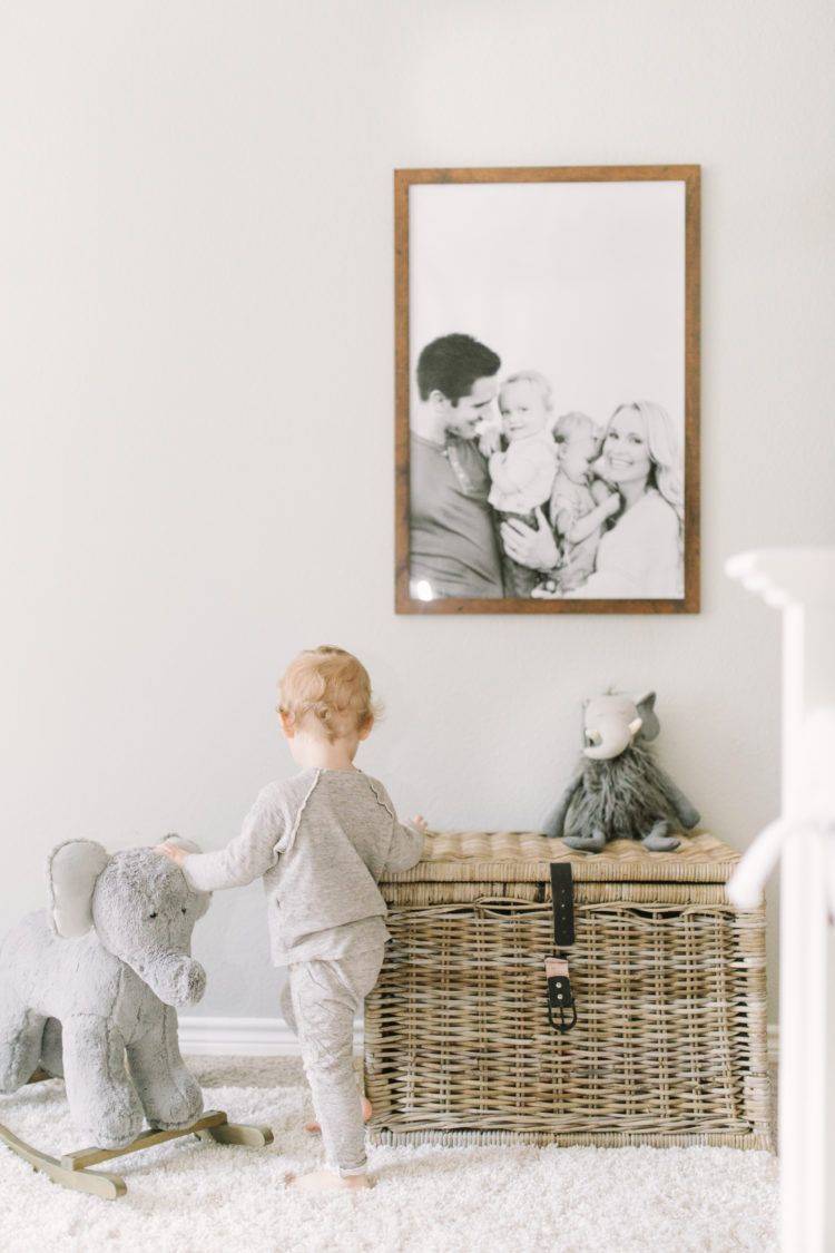 Habitación del bebé decorada con una foto familiar en blanco y negro en la pared