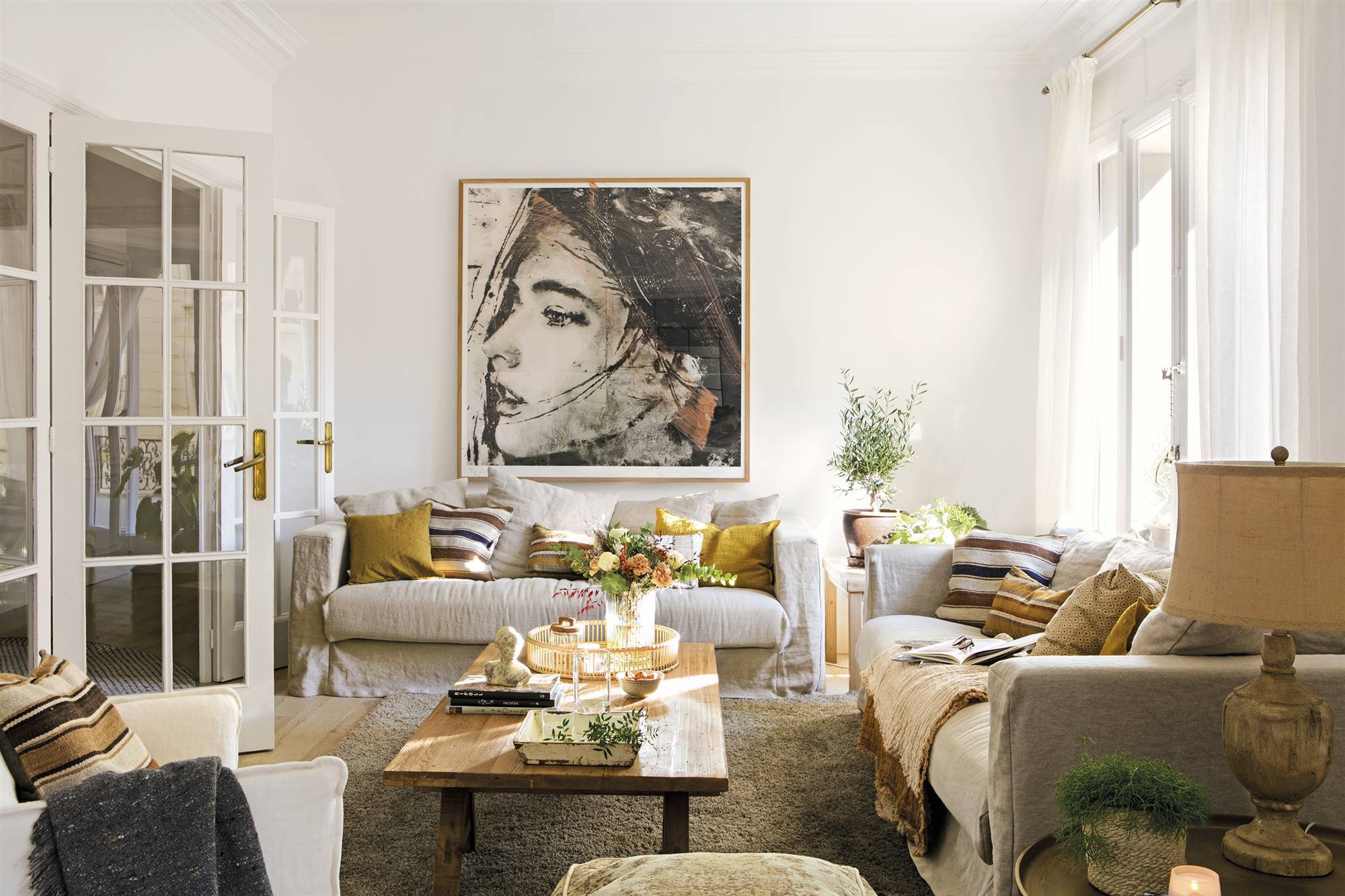 Salón con sofás beige y gran cuadro en la pared. 