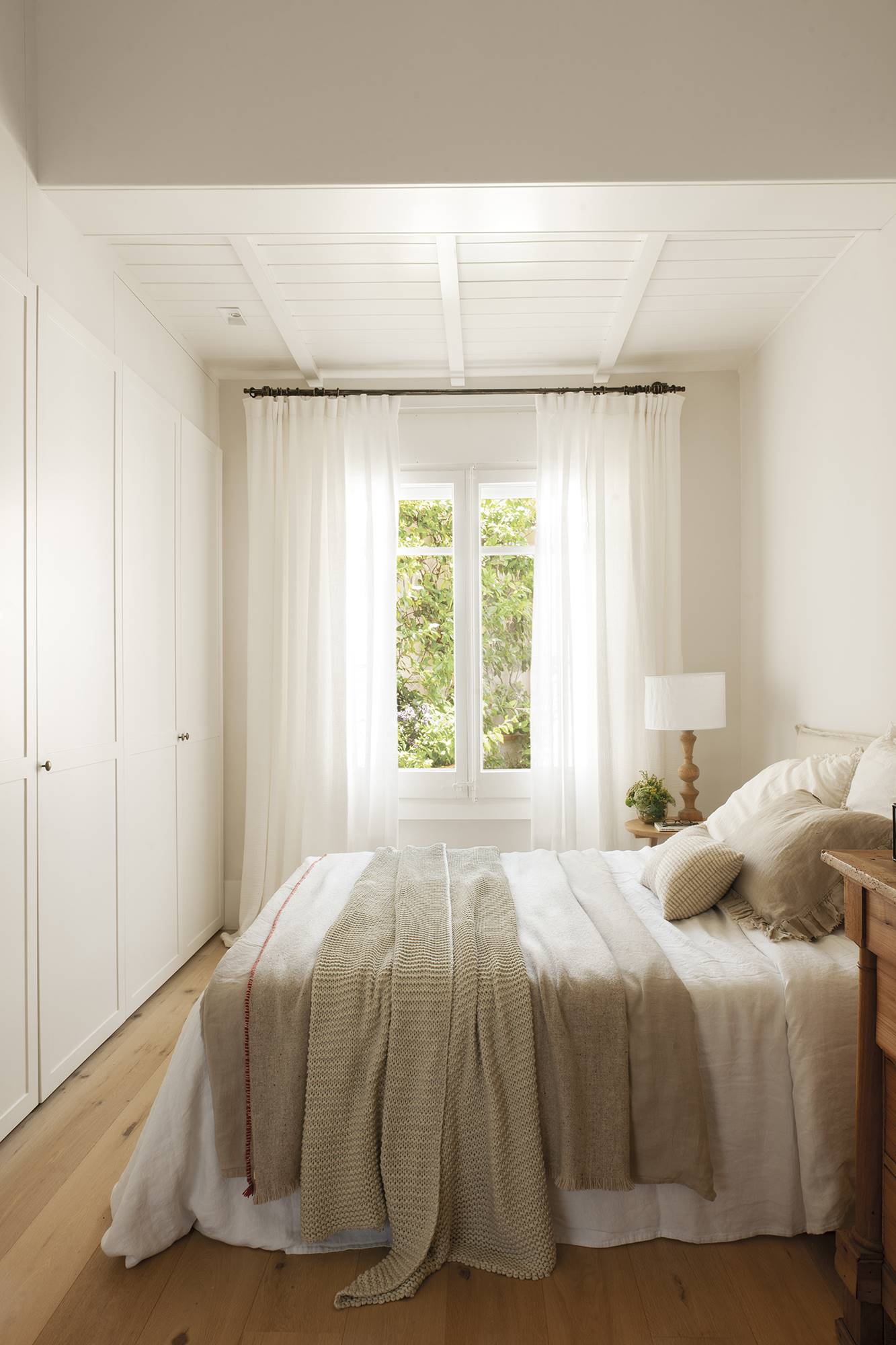 Dormitorio blanco con armarios a pie de cama