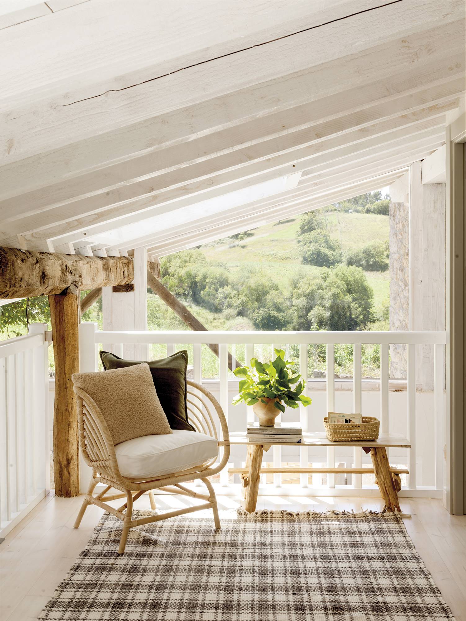 Terraza de estilo rústico con sillón y alfombra. 