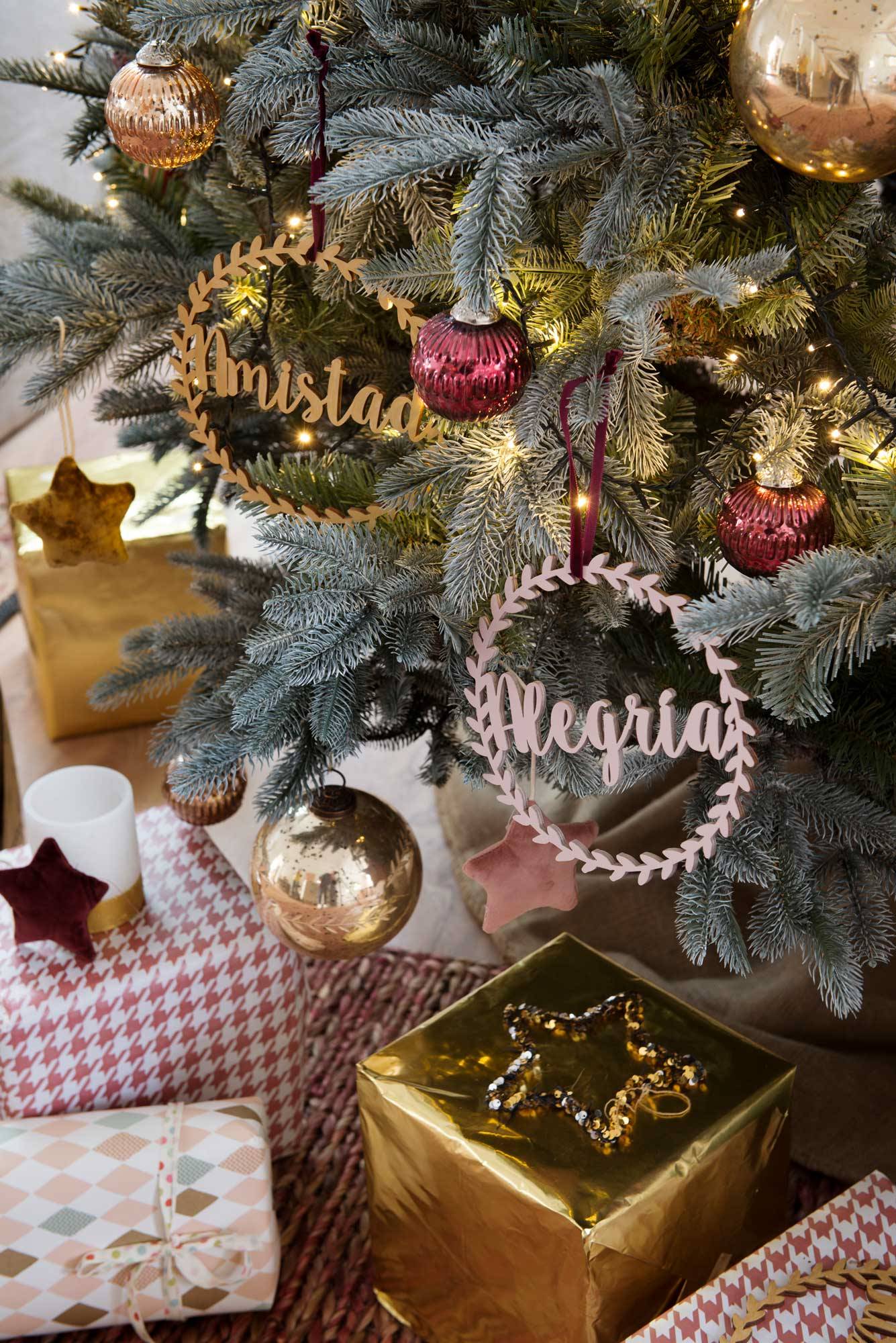 Árbol de Navidad con adornos y regalos debajo. 