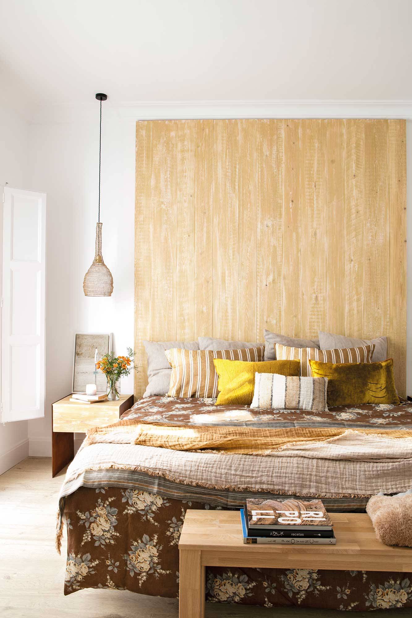 Dormitorio con maxi cabecero de madera y ropa de cama de colores de otoño_00514952