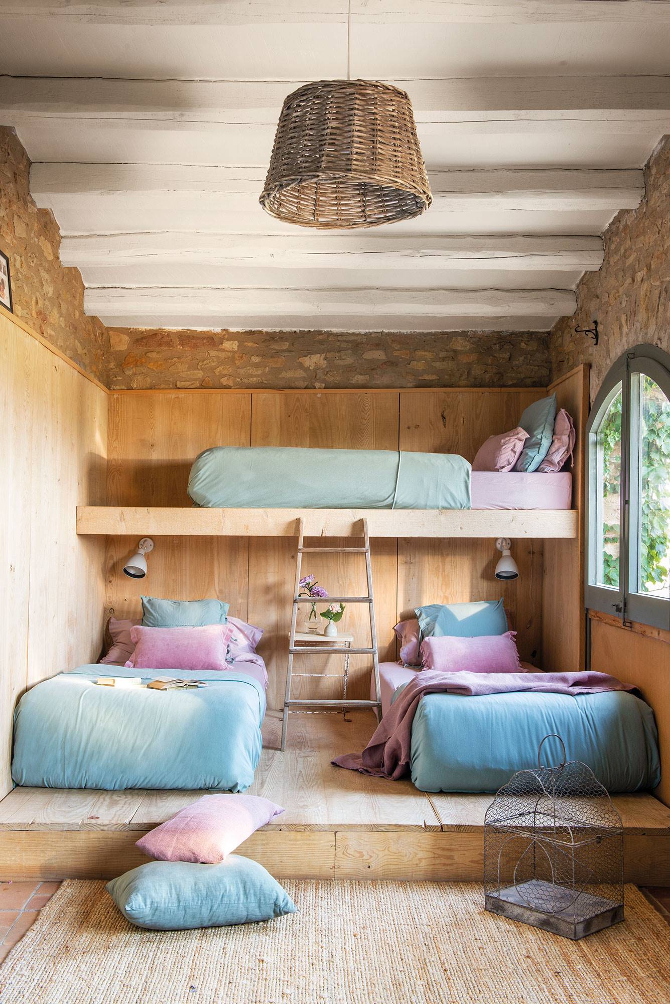 Dormitorio infantil con tres camas en litera de estilo rústico.