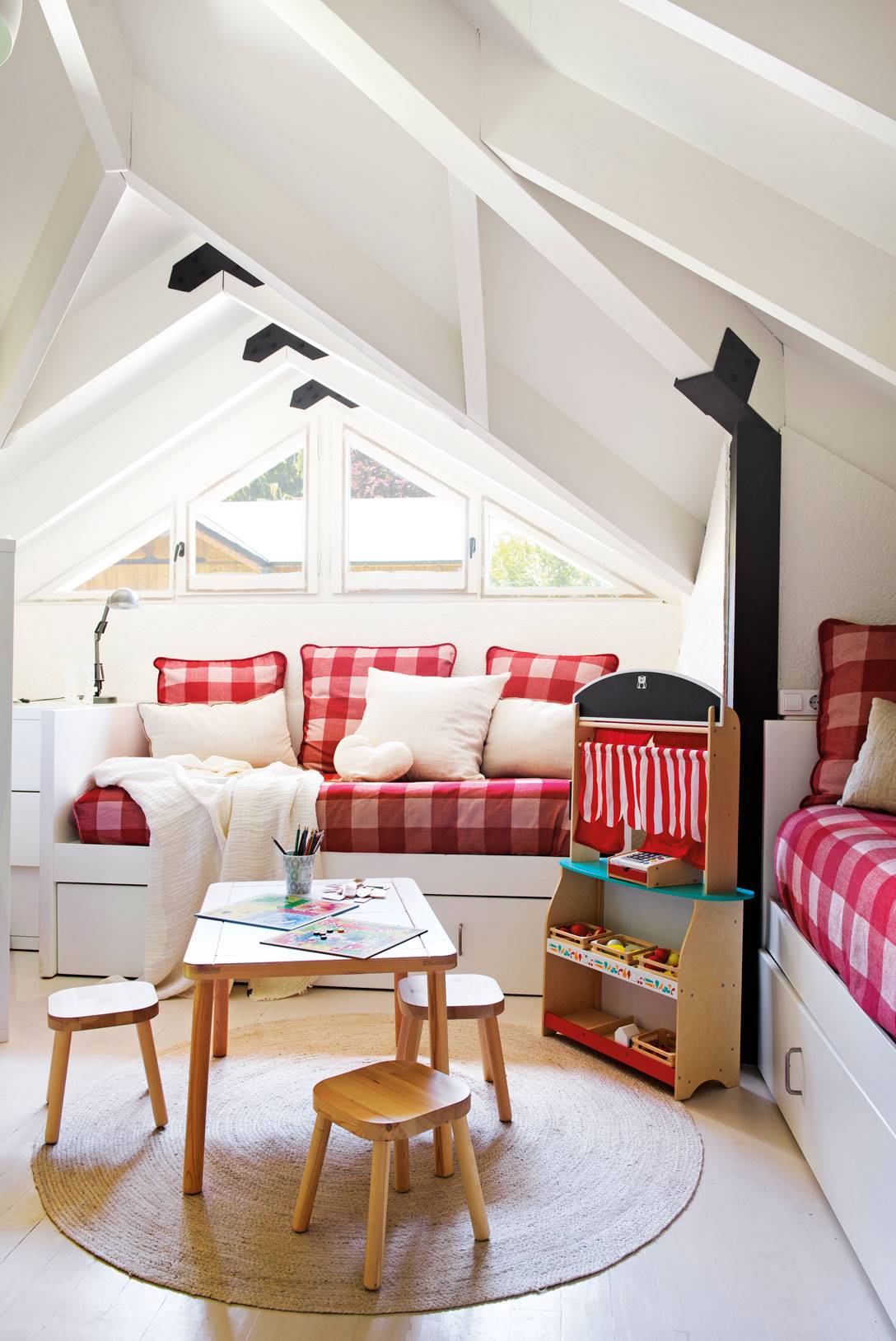 Dormitorio infantil con buhardilla en blancon y textiles vichy rojo y blanco.