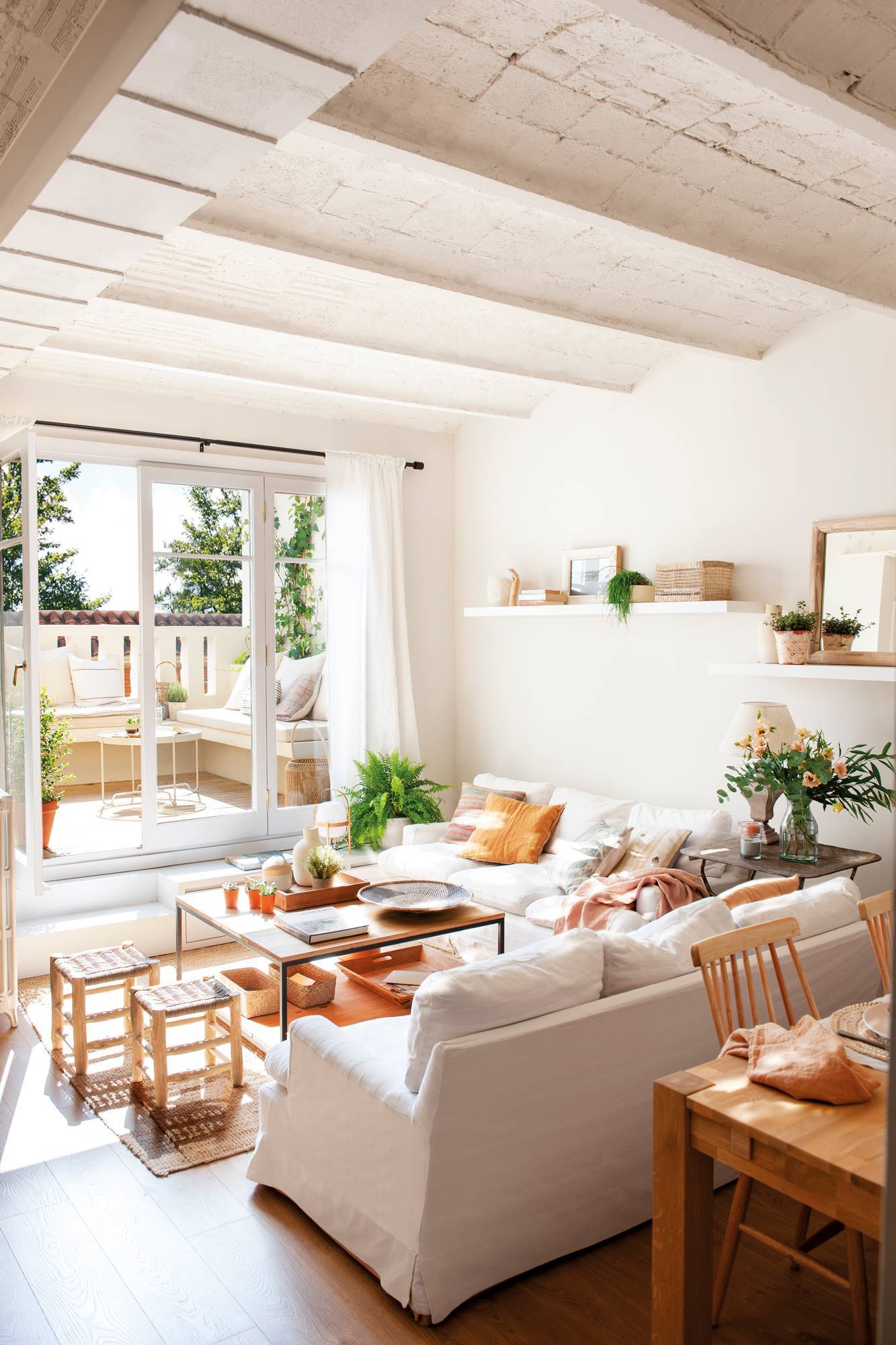 Salón pequeño en blanco con dos sofás en "L" y ventanal a la terraza 00513332