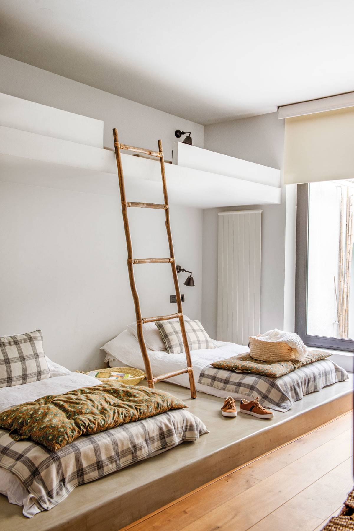 Dormitorio juvenil con camas tipo tatami, litera y escalera de madera.