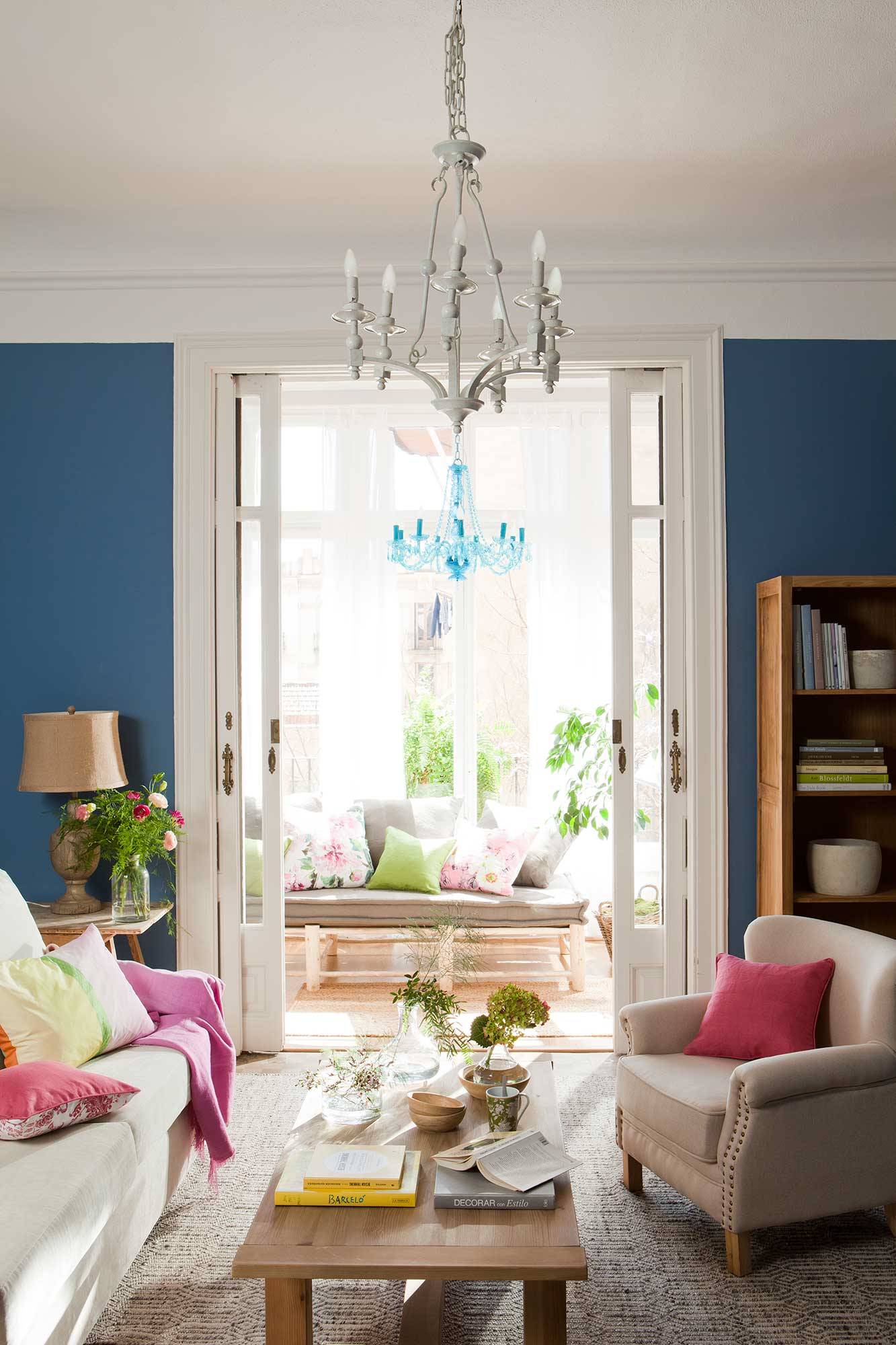 Salón regio con paredes azules y lámpara chandelier_00404173