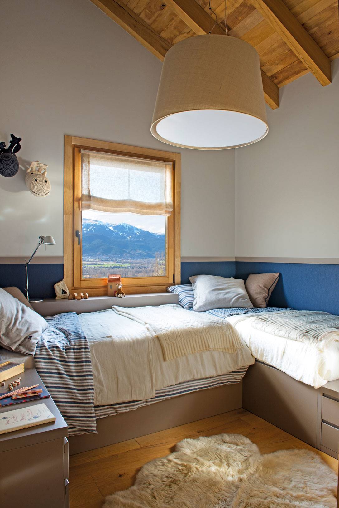 Dormitorio infantil pequeño con dos camas, arrimadero azul y techo abuhardillado-519995