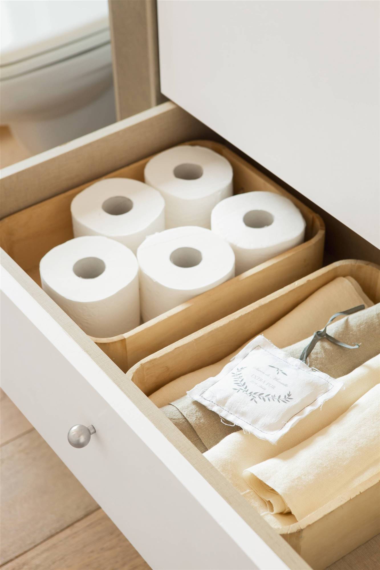 Detalle de cajón con papel higiénico y toallas. 