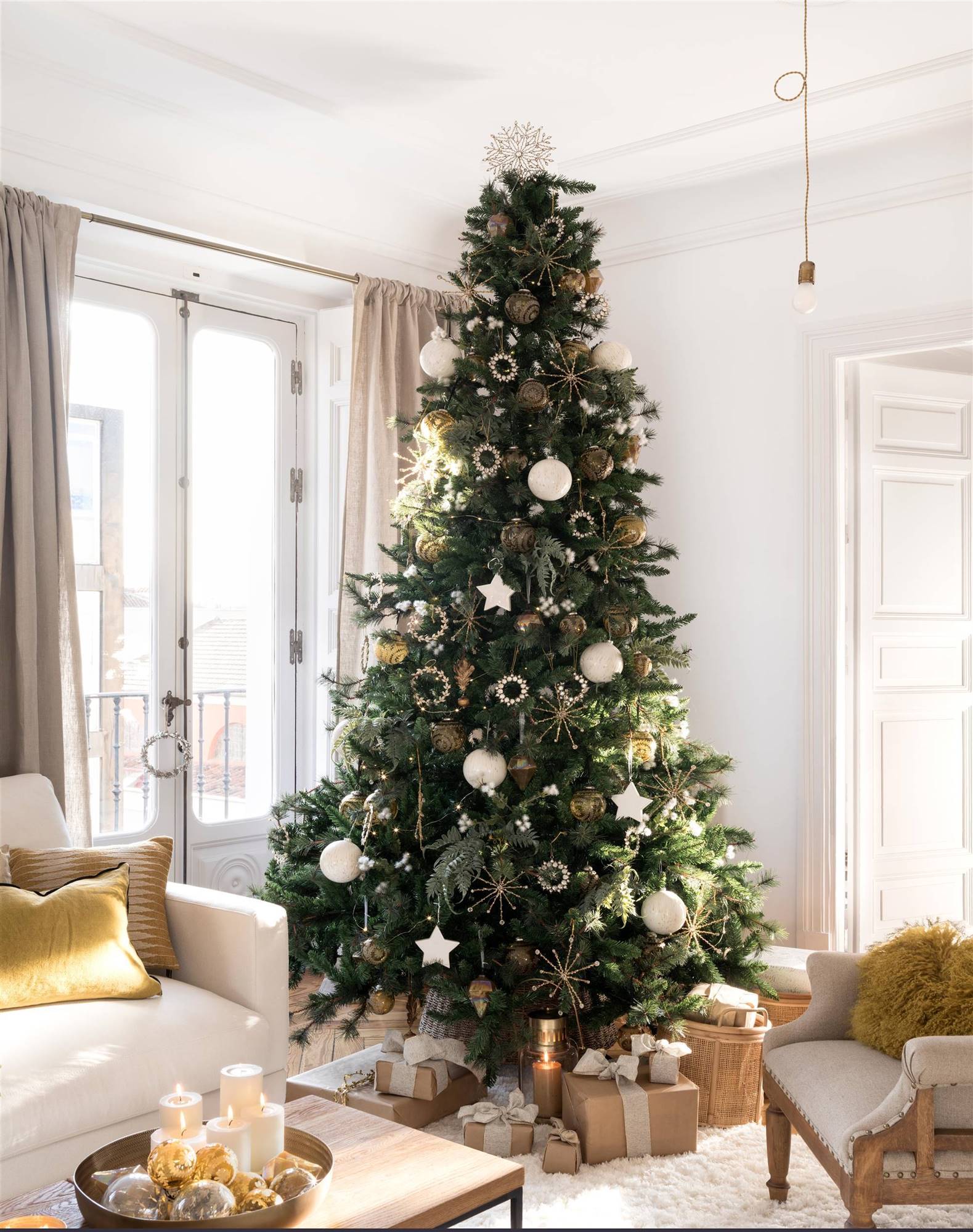 Un árbol de Navidad con adornos blancos y dorados.