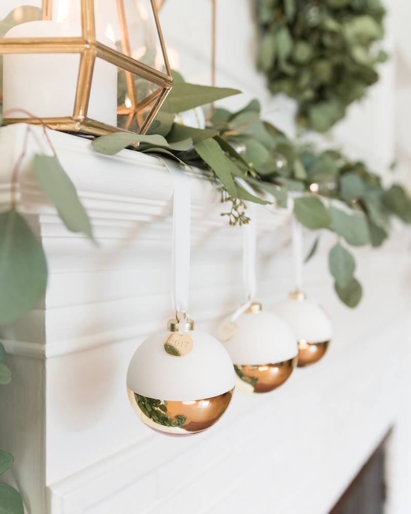 Bolas de Navidad blancas y doradas en la chimenea.